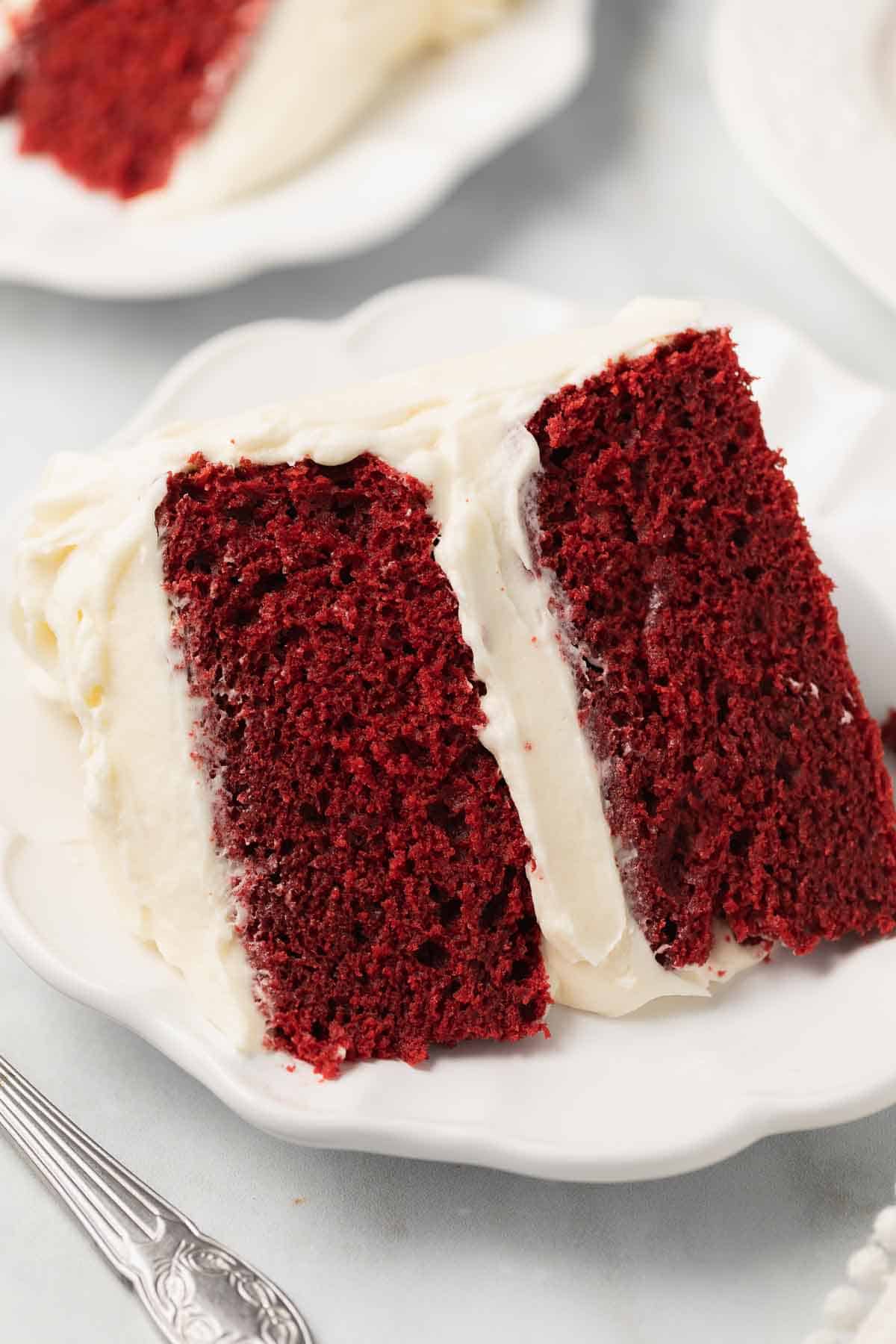 gluten free red velvet cake on white plate with fork before serving