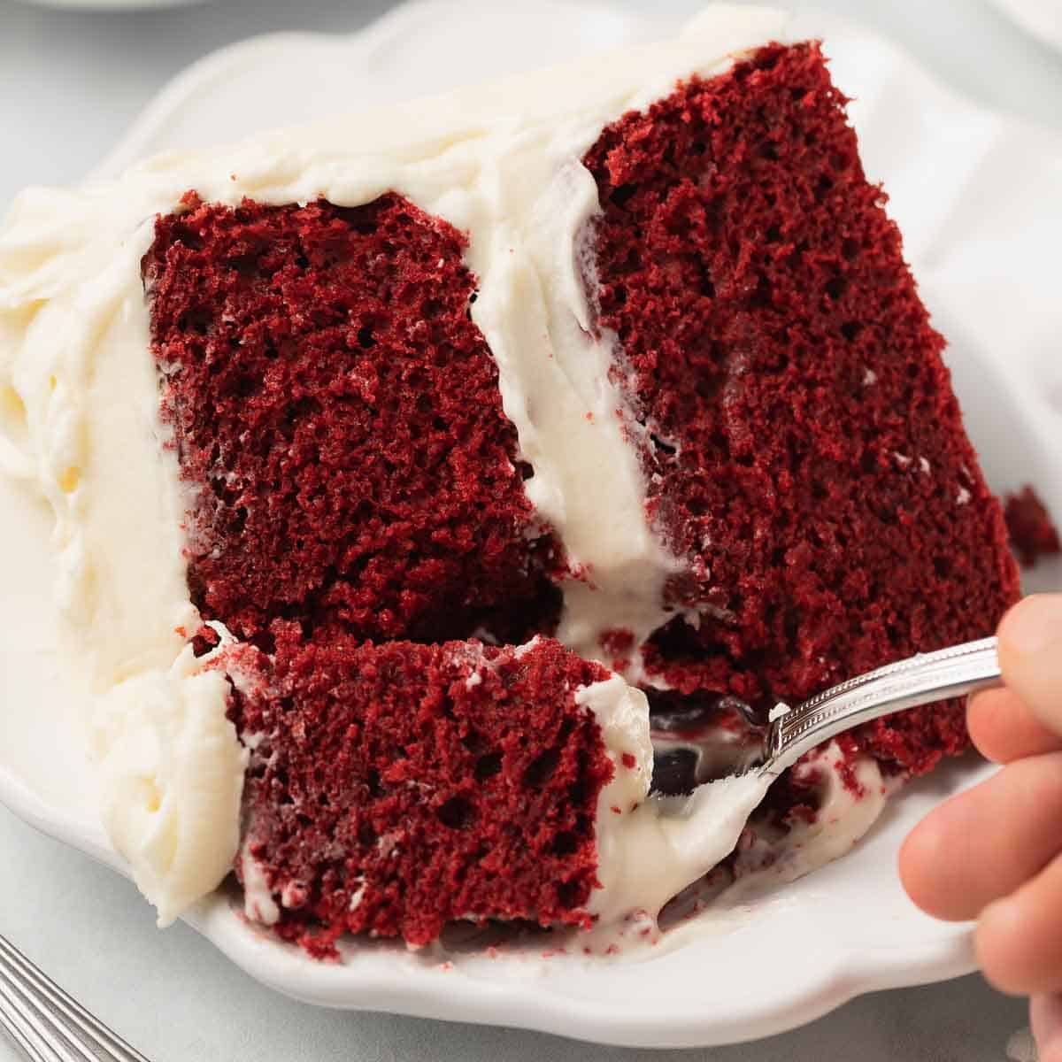 fork taking bite out of red velvet cake