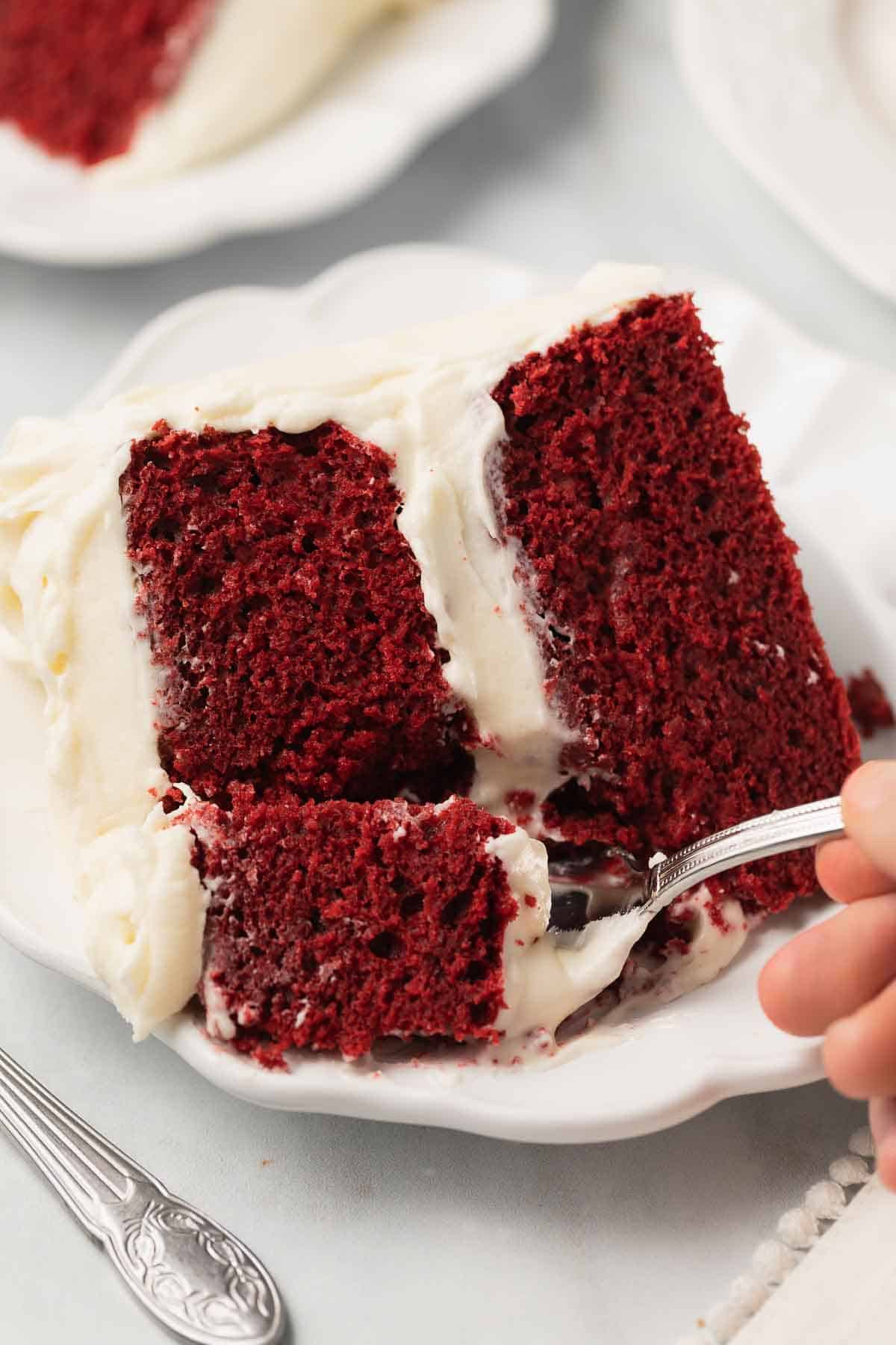 fork taking bite out of red velvet cake