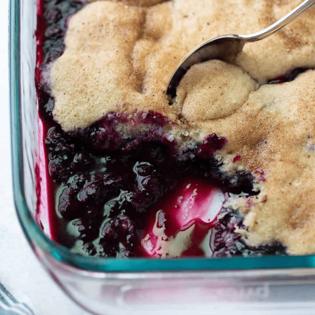 Blueberry cobbler in a pan, with a slice taken out