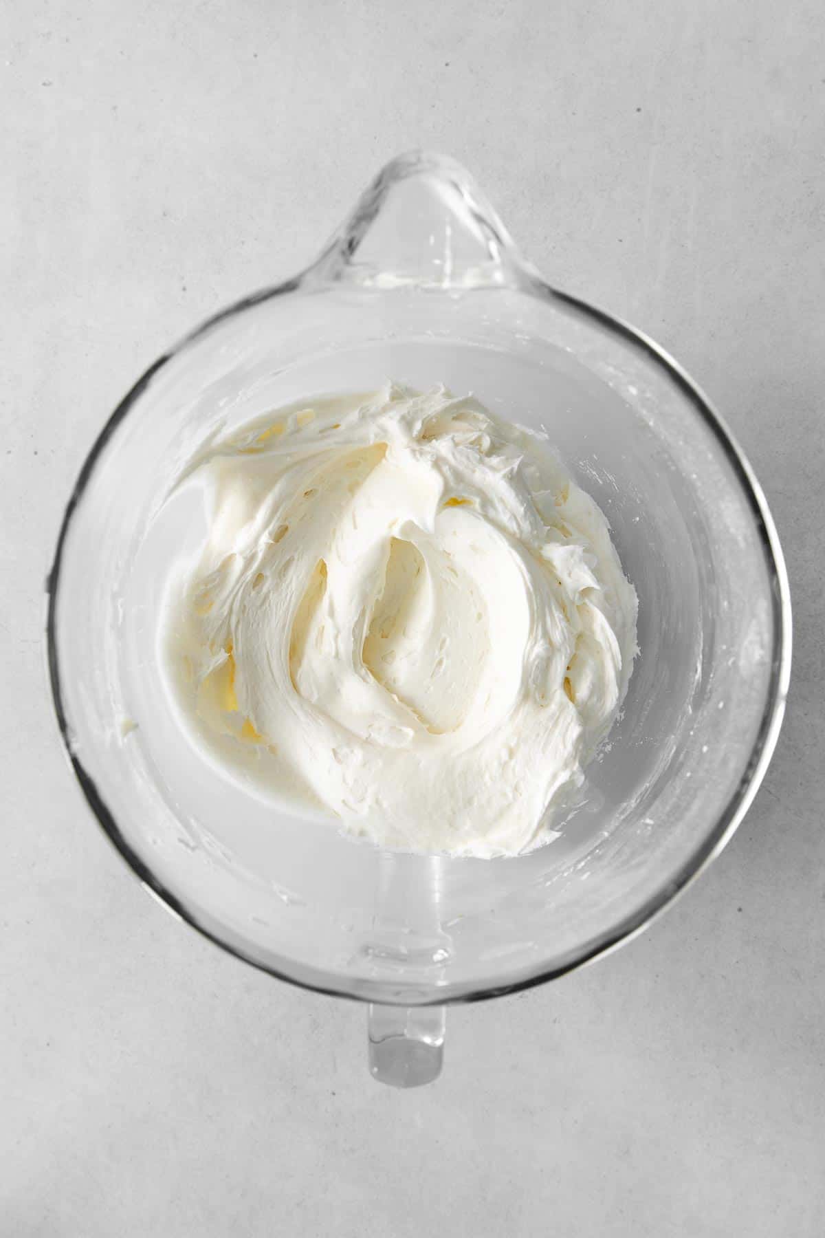 whipped cream cheese frosting in a glass bowl