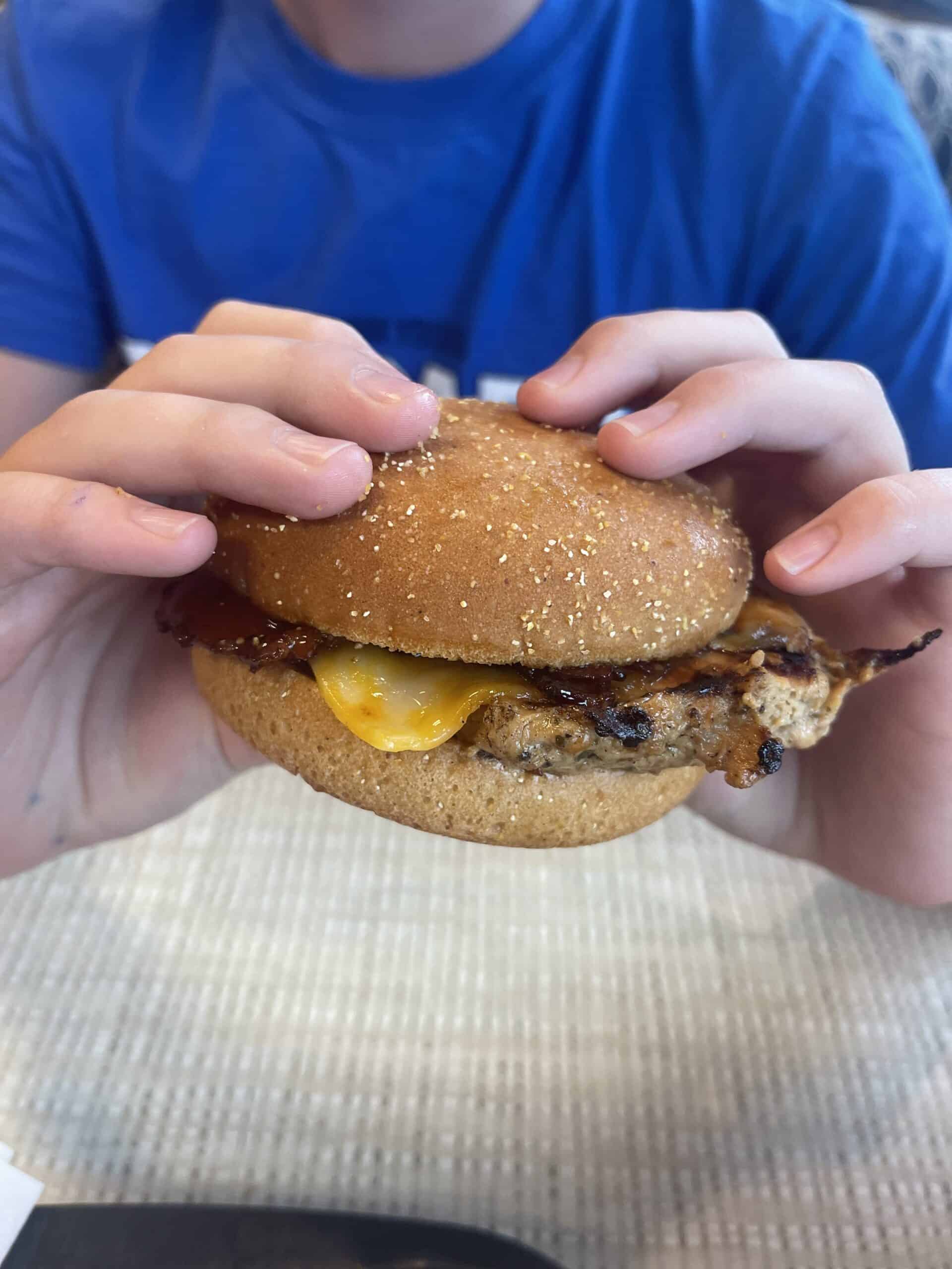 Someone holding a Chick-fil-A grilled chicken sandwich on a gluten-free bun