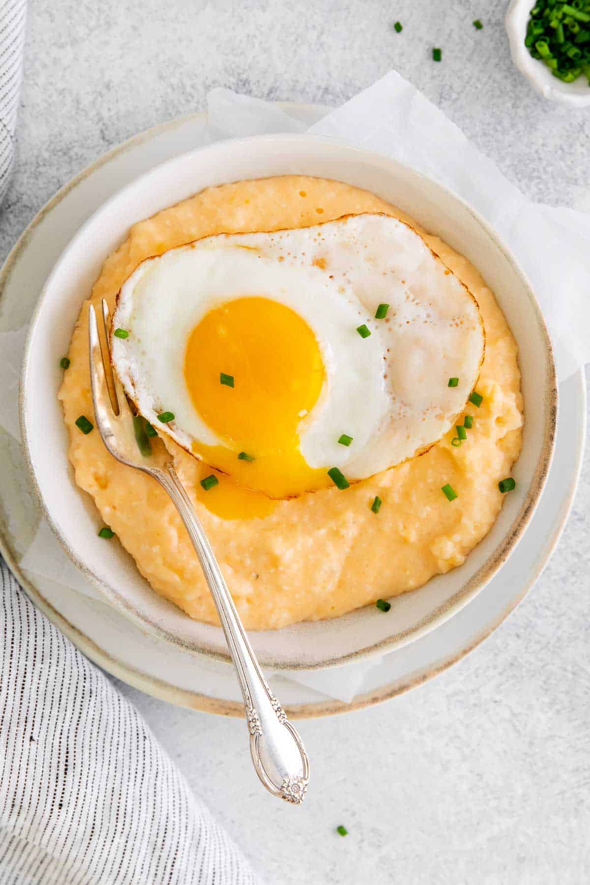 Grits and eggs in a bowl with a spoon