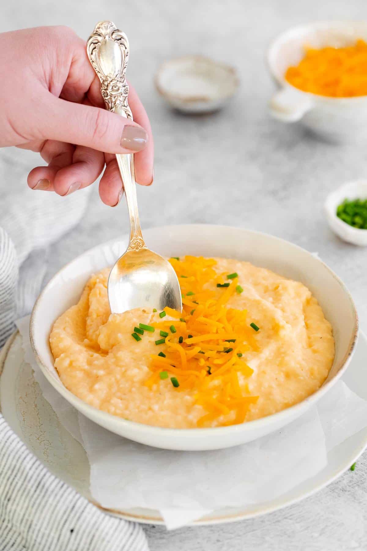 Cream cheese grits in a bowl with a spoon