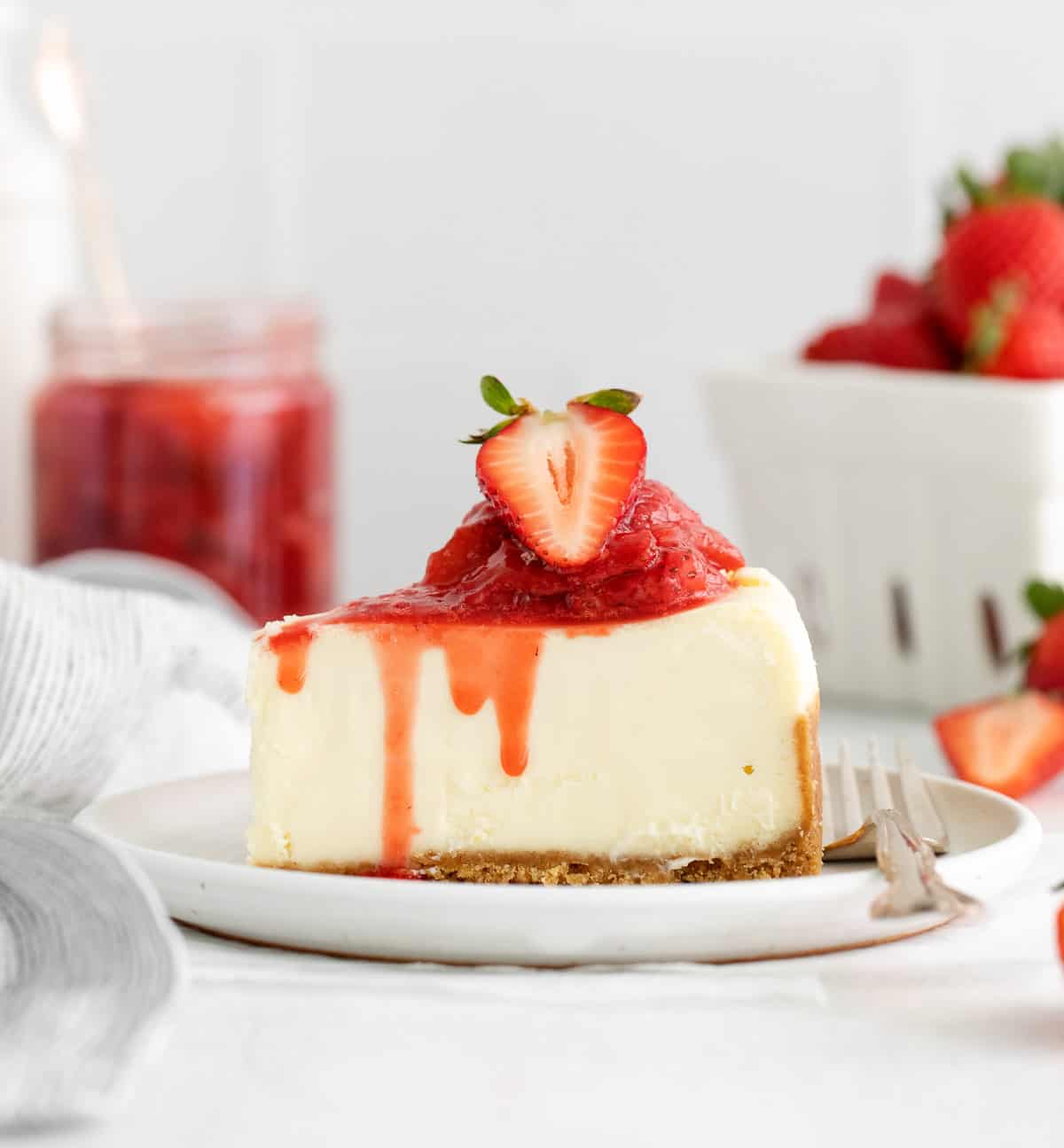 A slice of cheesecake with strawberry compote on top