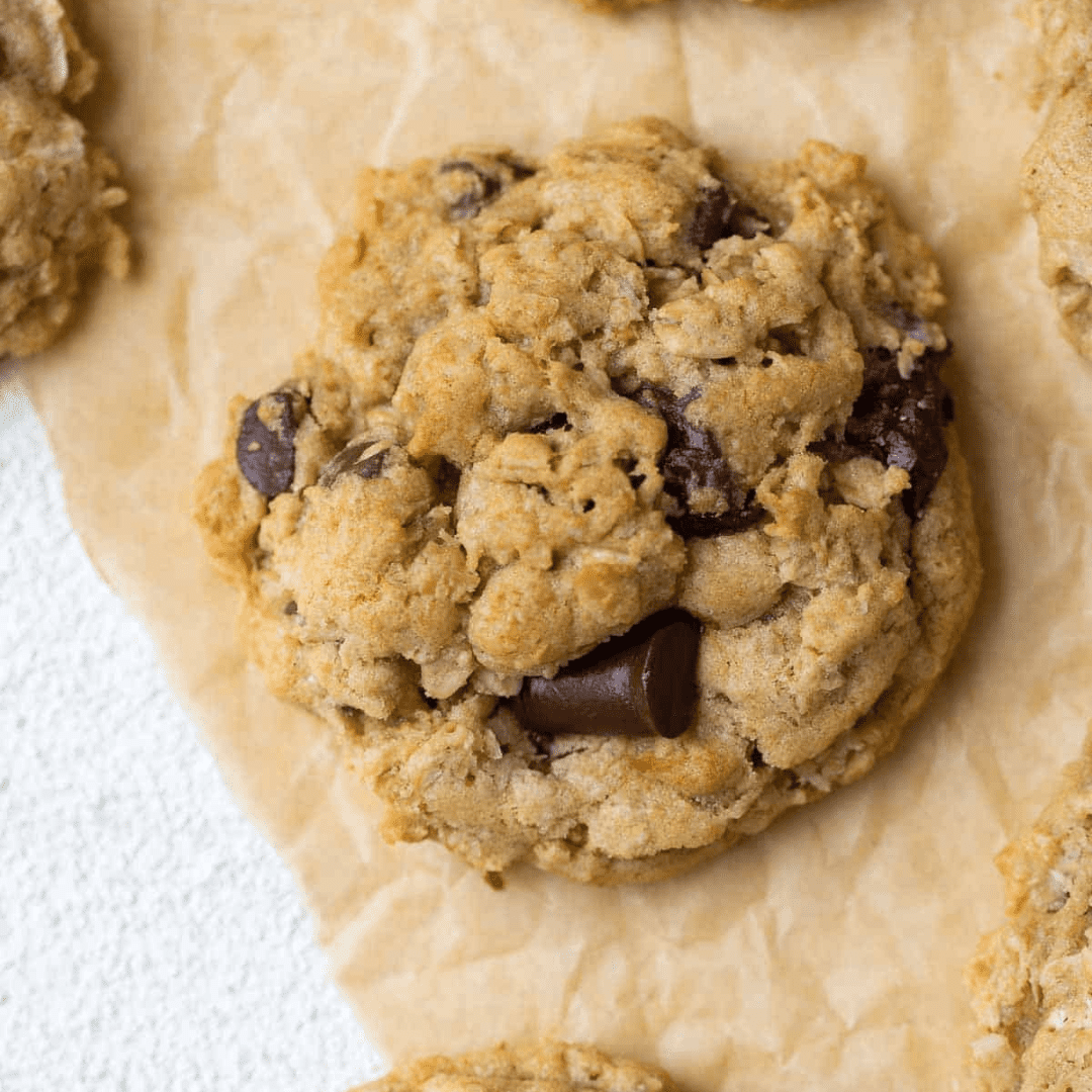A large oatmeal chocolate chunk cookie on parchment paper
