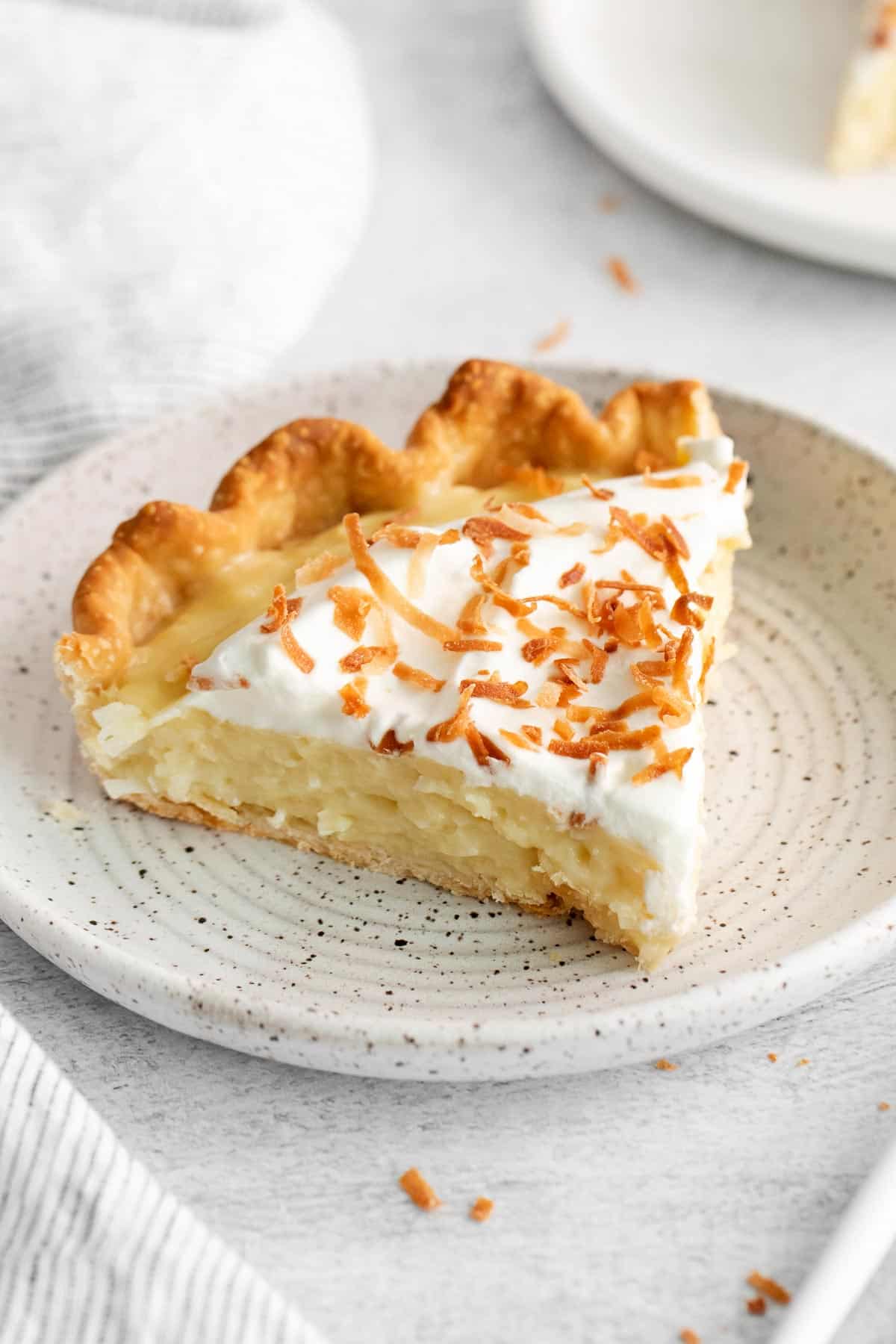 A slice of coconut cream pie on a plate