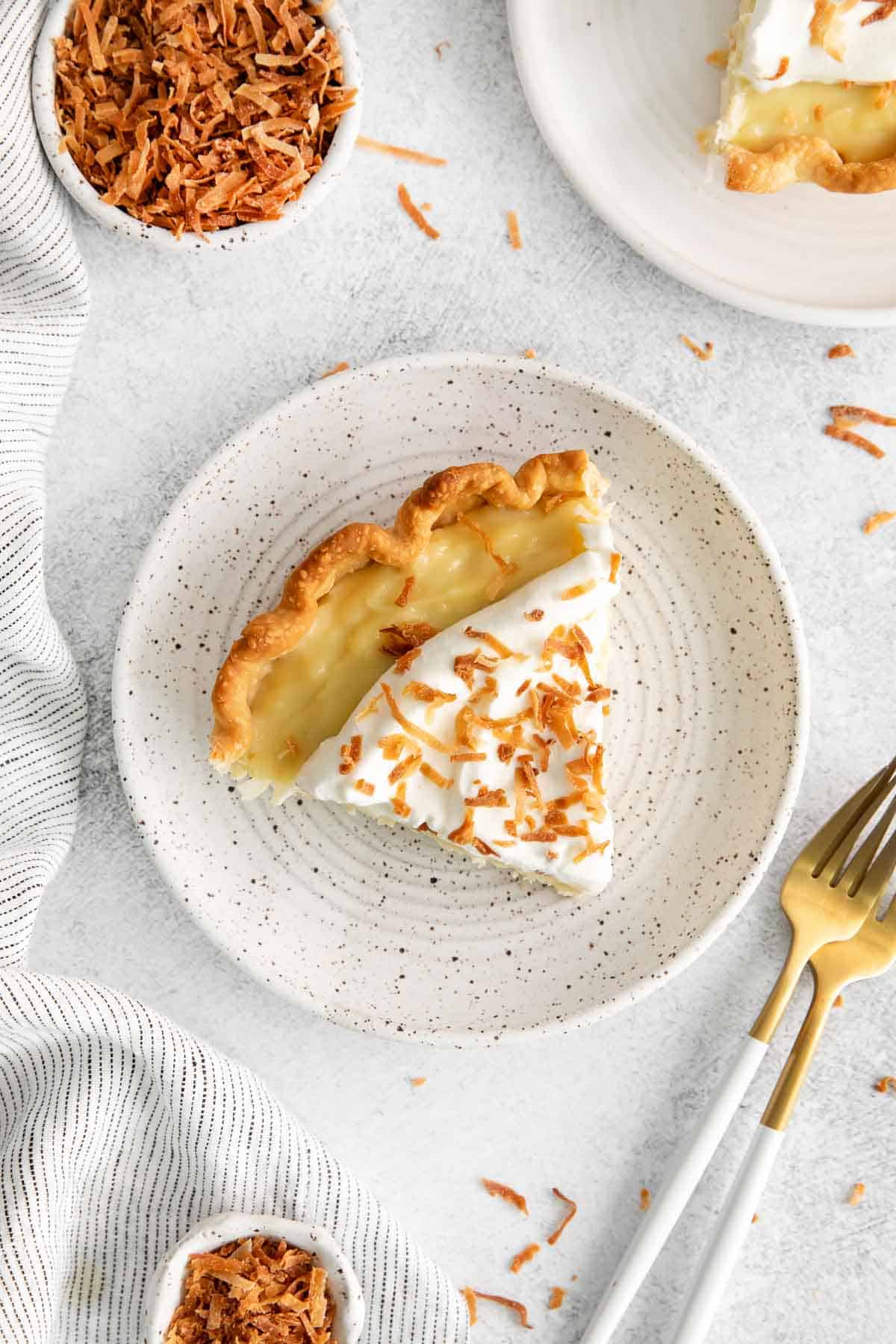 An overhead look at a slice of coconut cream pie on a plate