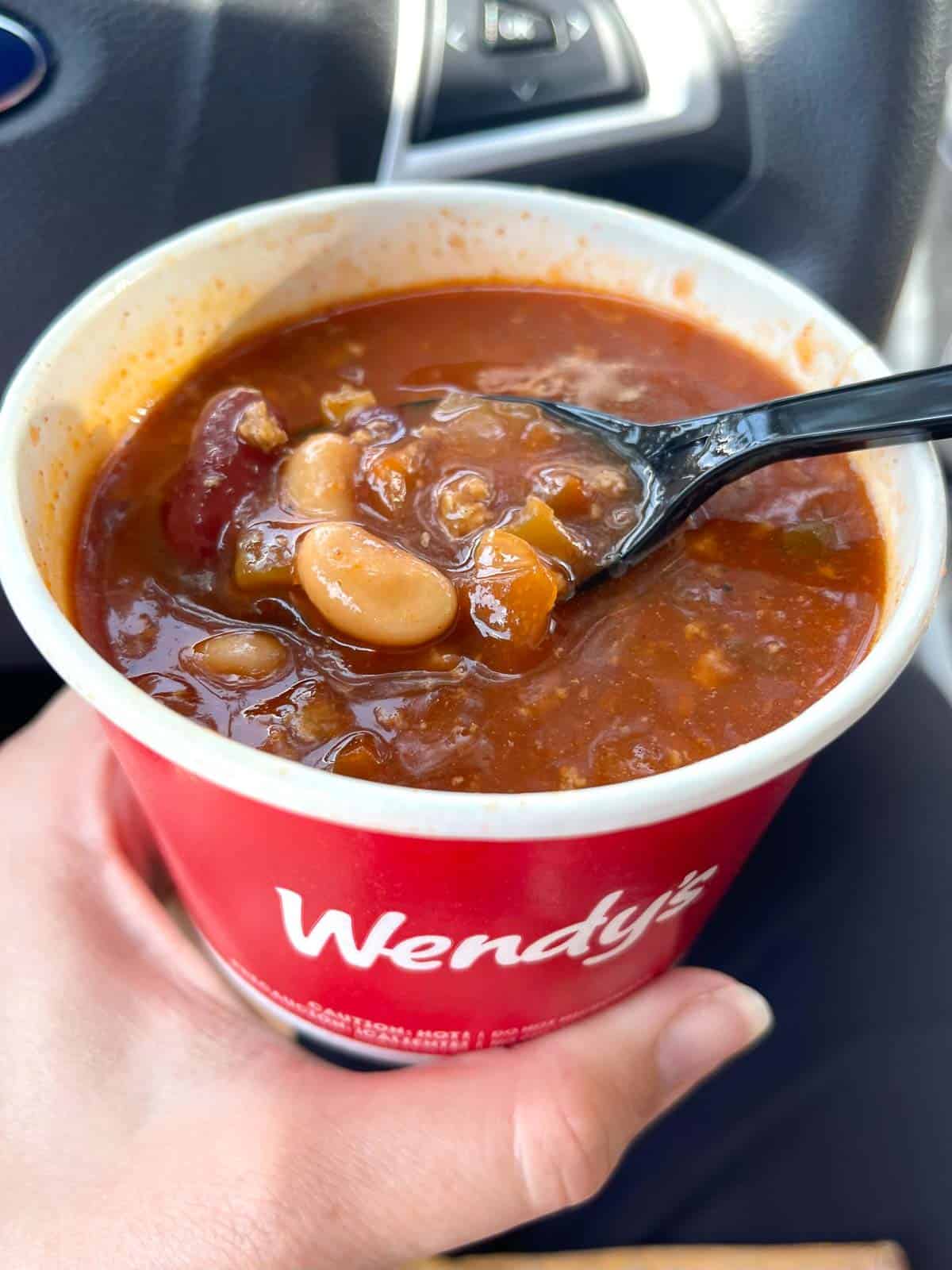 Wendy's chili in a cup with a spoon in it