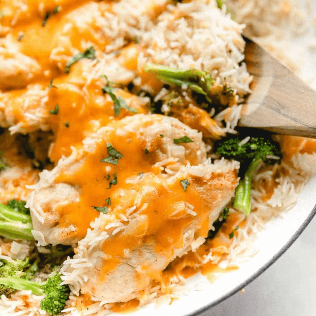 Chicken, broccoli, and rice topped with cheese on a plate