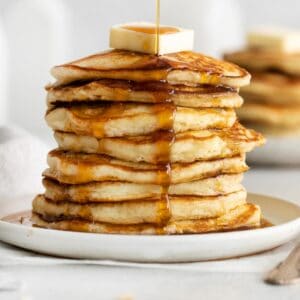 A close-up of buttermilk pancakes stacked on a plate
