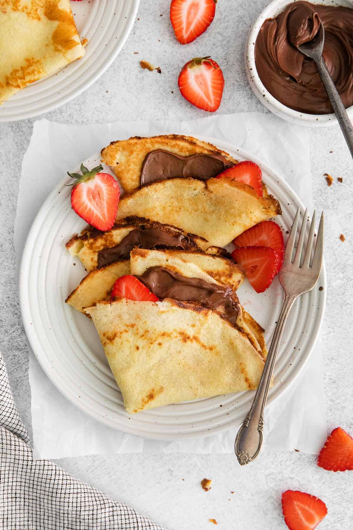 Crepes on a plate with a fork next to it