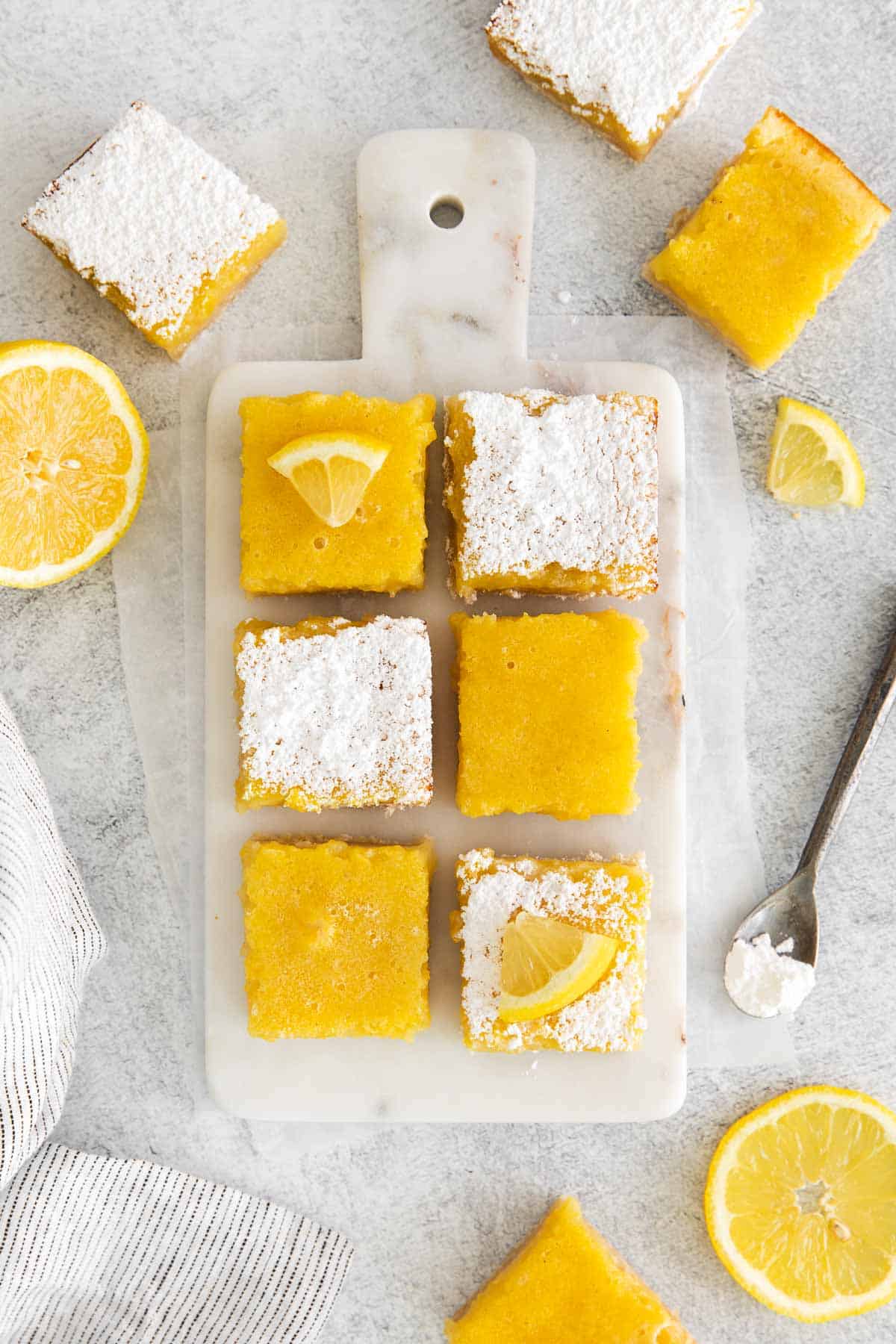 gluten-free lemon bars with powdered sugar and lemon slices on top
