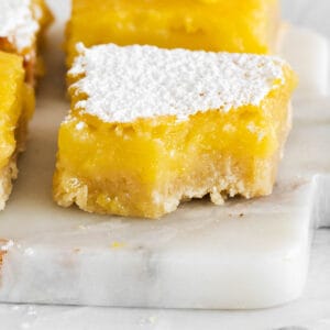 a close-up of a gluten-free lemon bar with a bite taken out of it