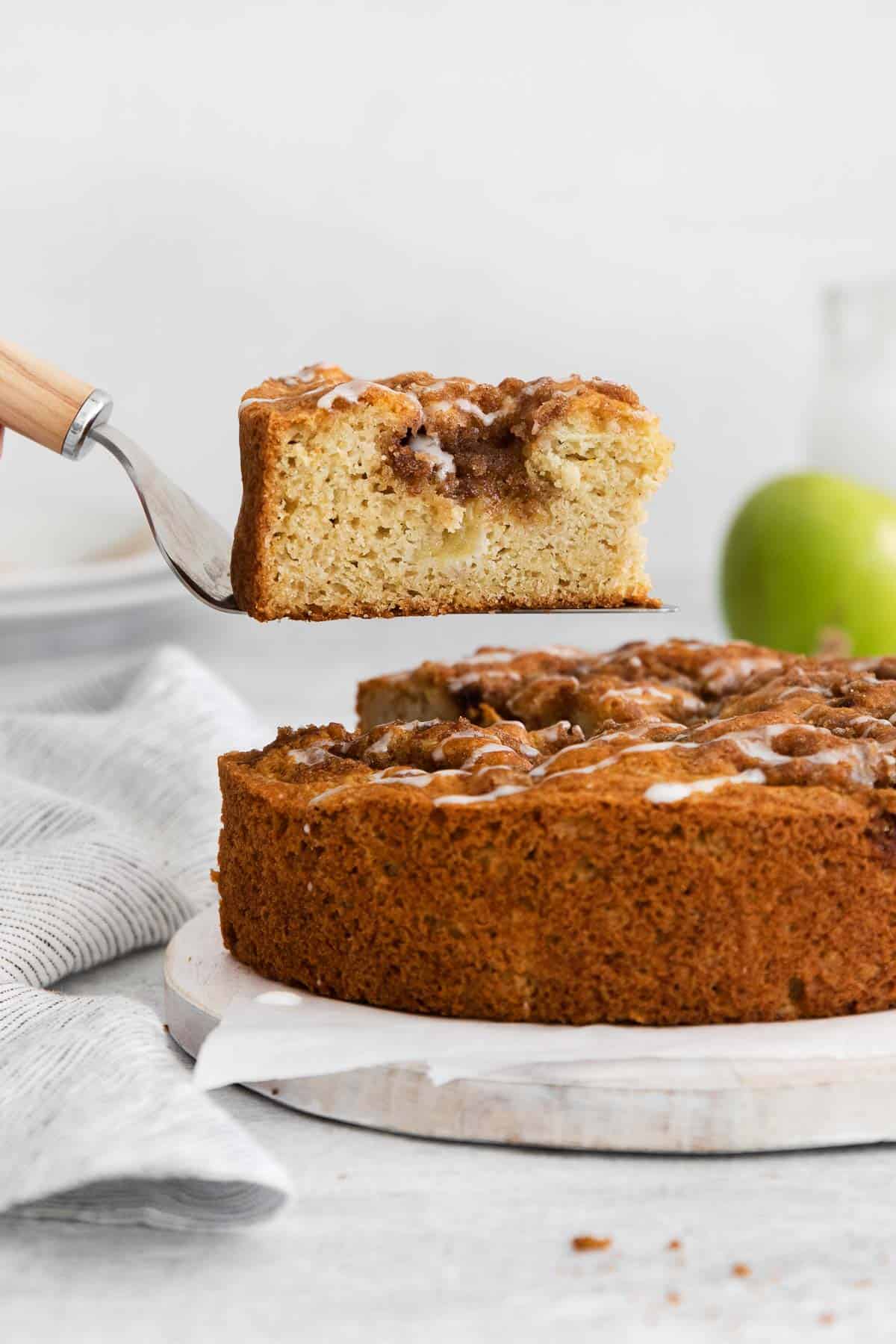 A spatula taking a slice of cake out of the apple cake