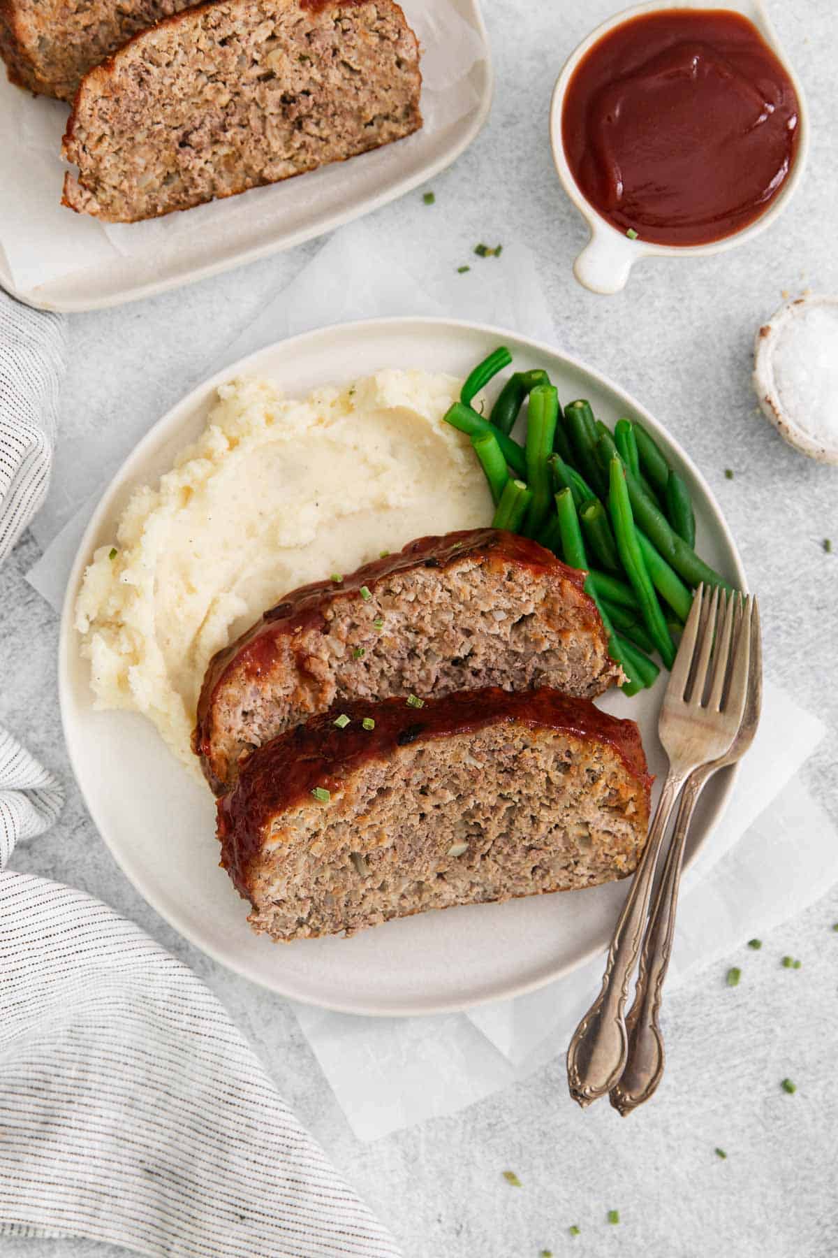Gluten-free meatloaf arranged on a plate with mashed potatoes and green beans