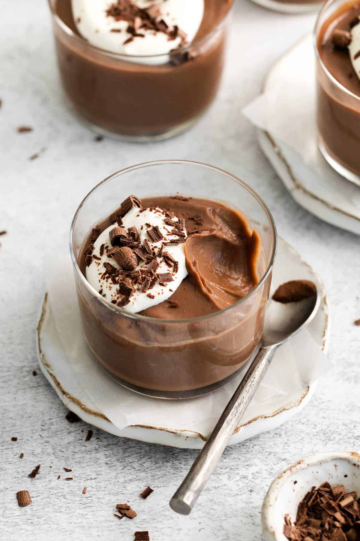 A glass ramekin filled with chocolate pudding