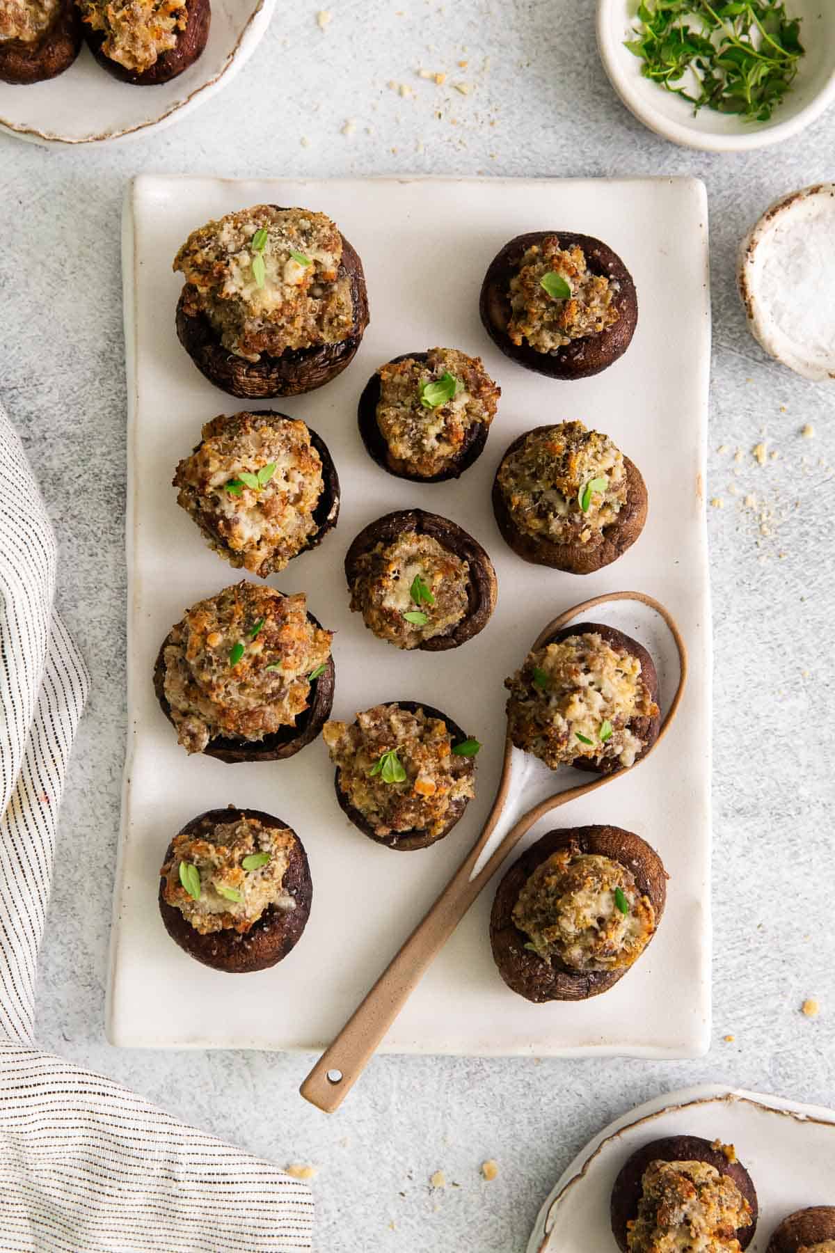 Gluten-free stuffed mushrooms on a platter with a serving spoon