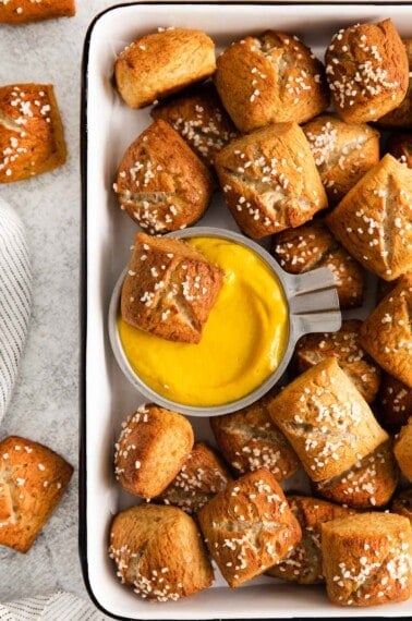 gluten-free soft pretzels in a baking dish with cheese dip