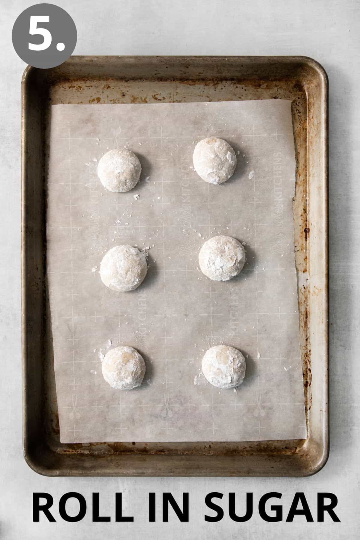 gluten-free snowball cookies rolled in sugar on a baking sheet