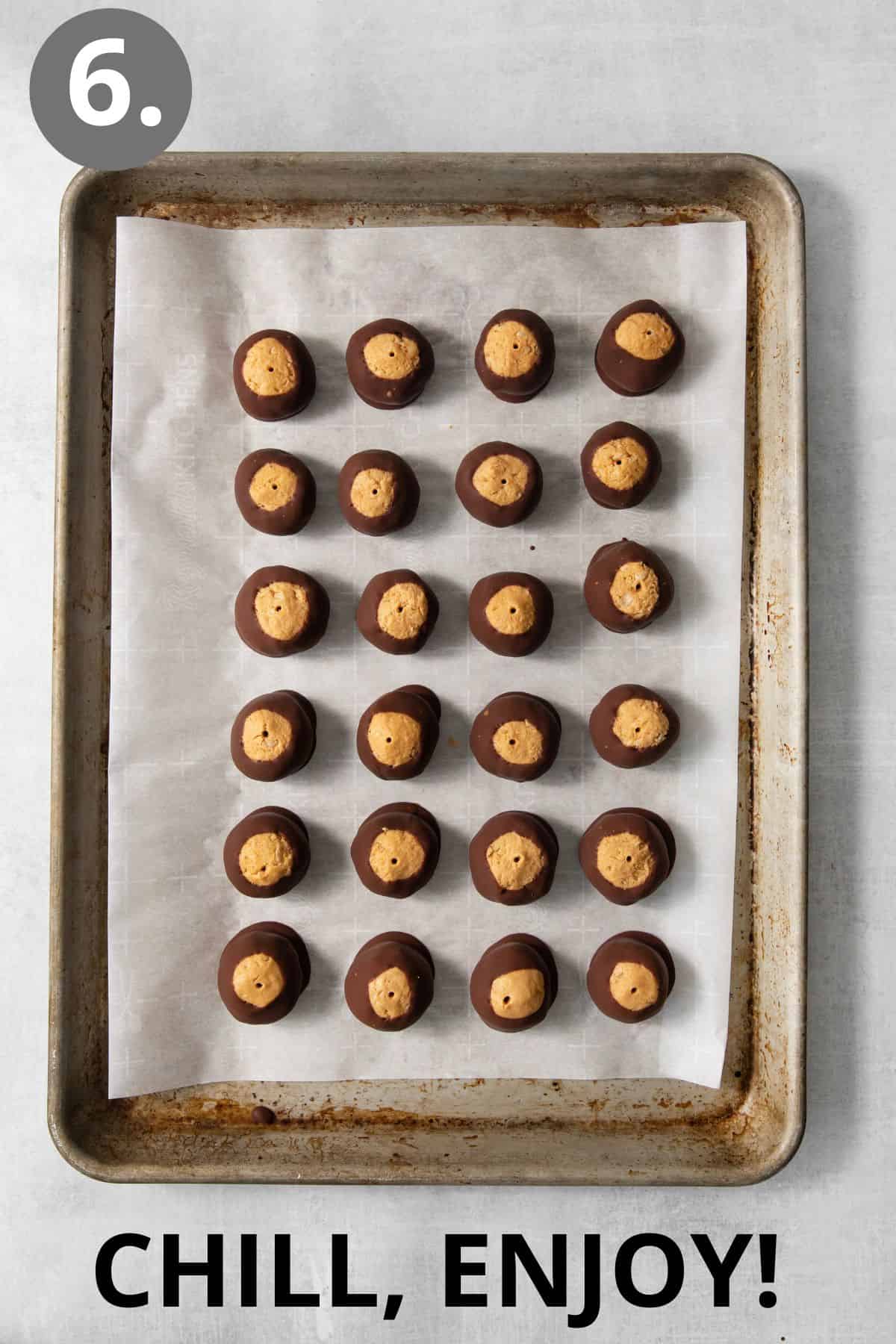 Dipped peanut butter balls sitting on a baking sheet