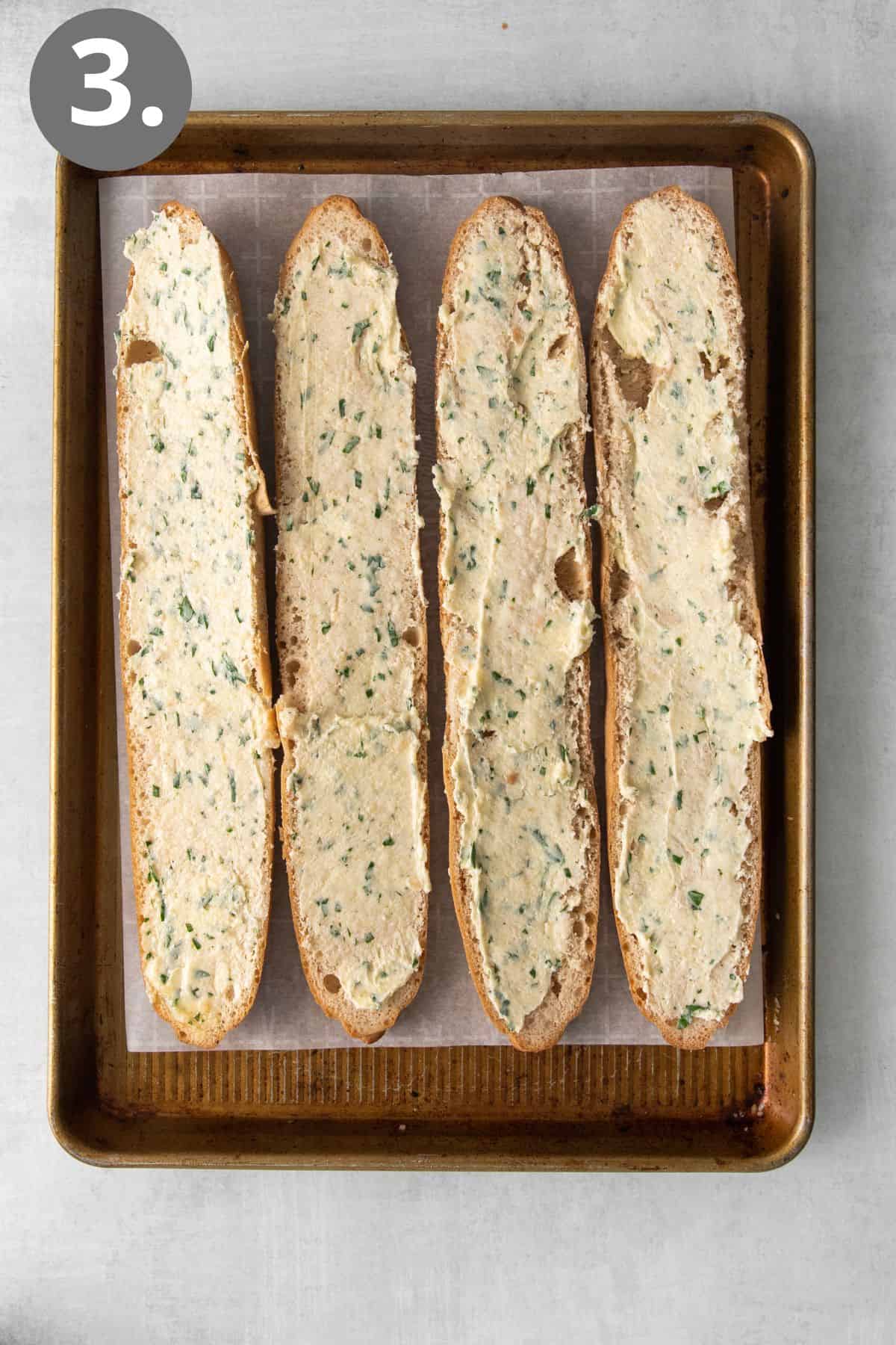 Gluten-free bread with garlic butter slathered on top, ready to be baked on a baking sheet