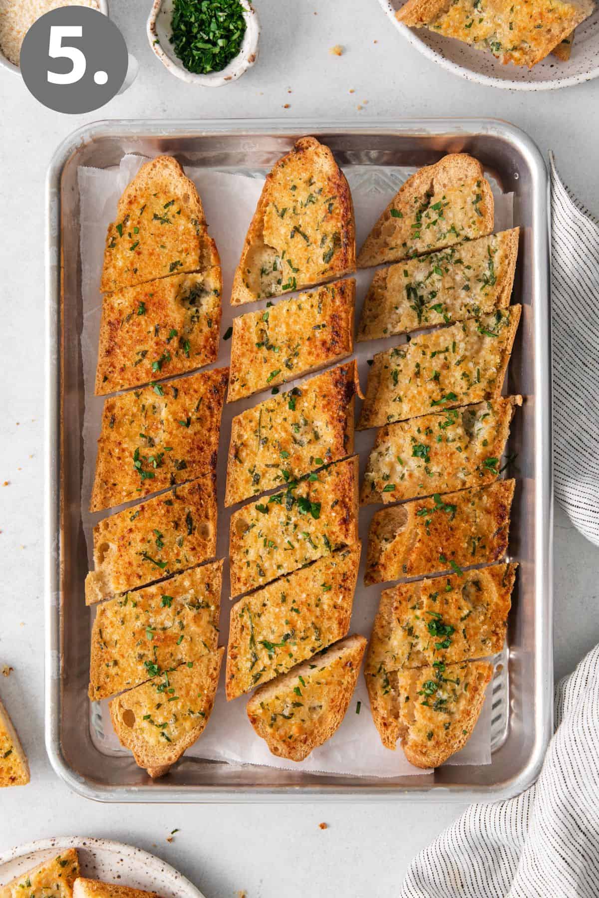 Gluten-free garlic bread loaves sliced on a baking sheet