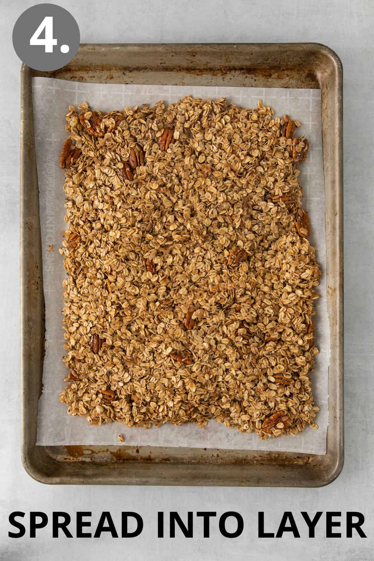 Granola spread in a layer on a baking sheet