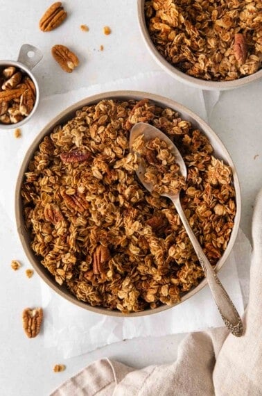 An overhead view of Gluten-free granola in a bowl with a spoon in it