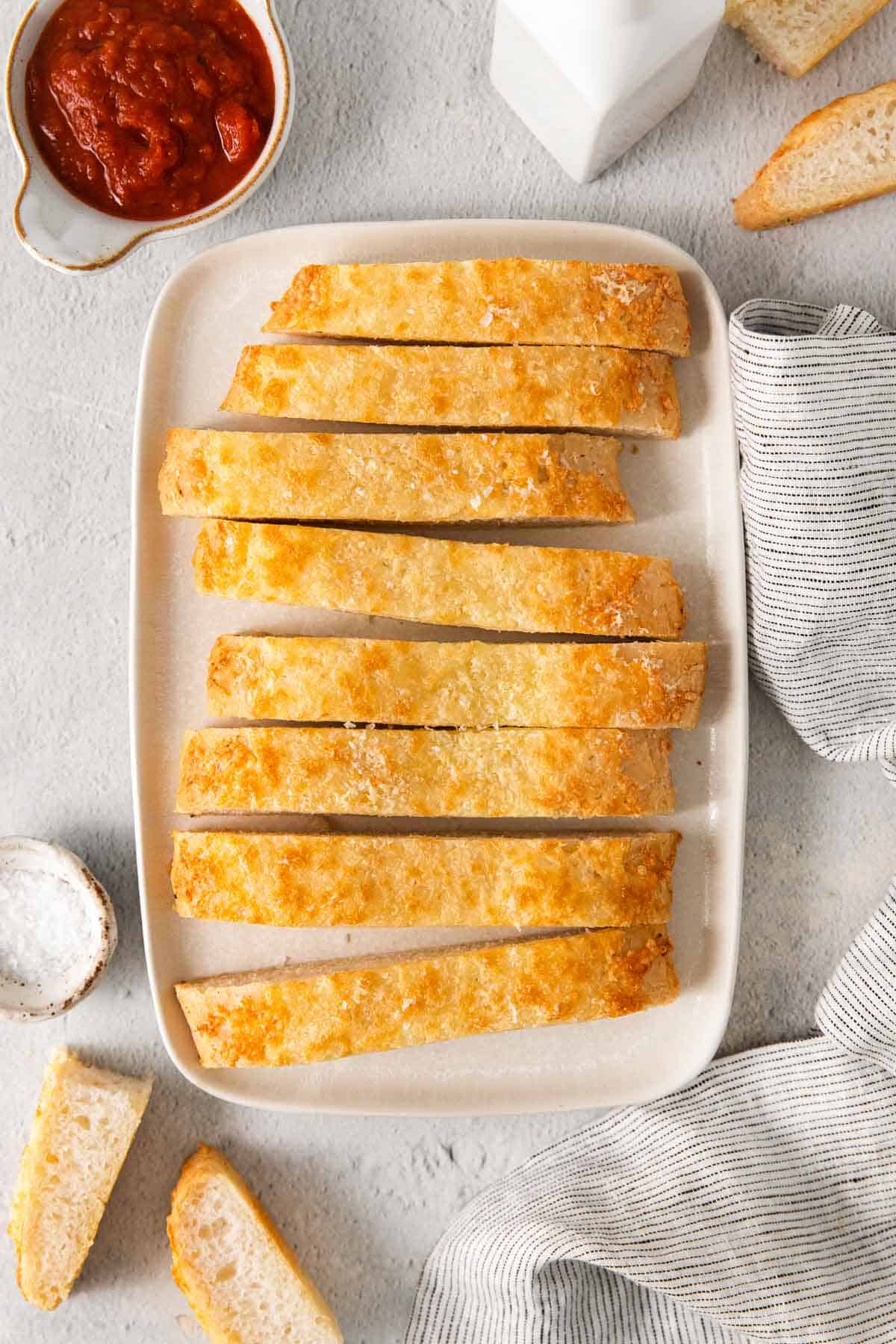 gluten-free breadsticks on a platter with butter and marinara sauce