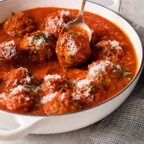 Gluten-free meatballs in a serving dish and a fork reaching in to pick up a meatball