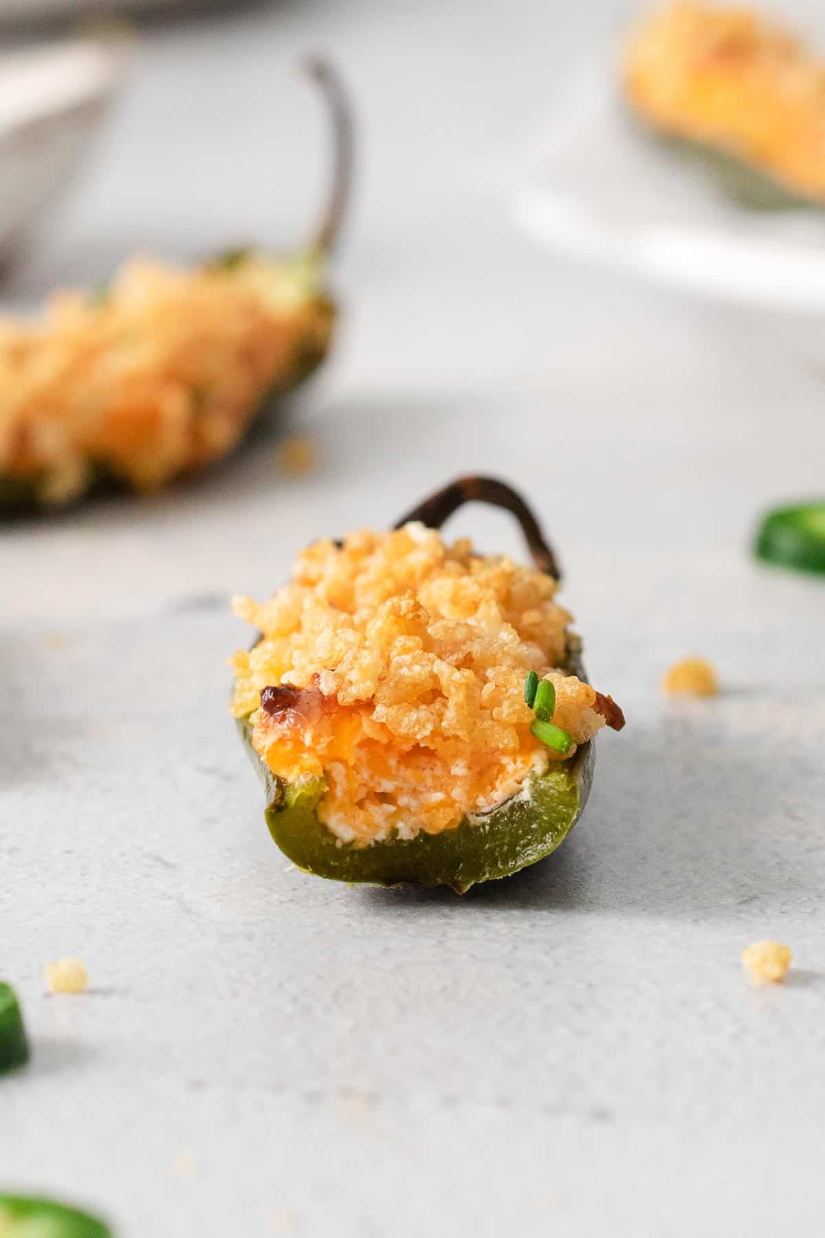 A jalapeno popper with a bite taken out of it