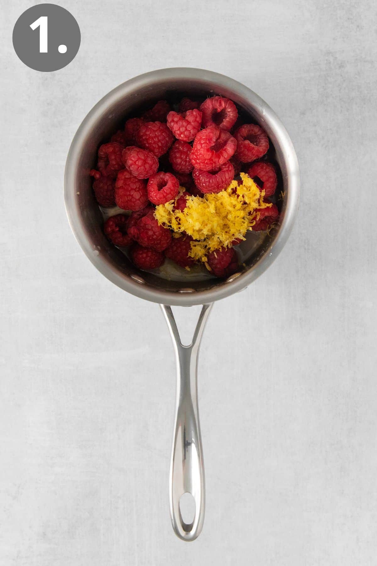 Raspberries, sugar, and lemon zest in a sauce pan