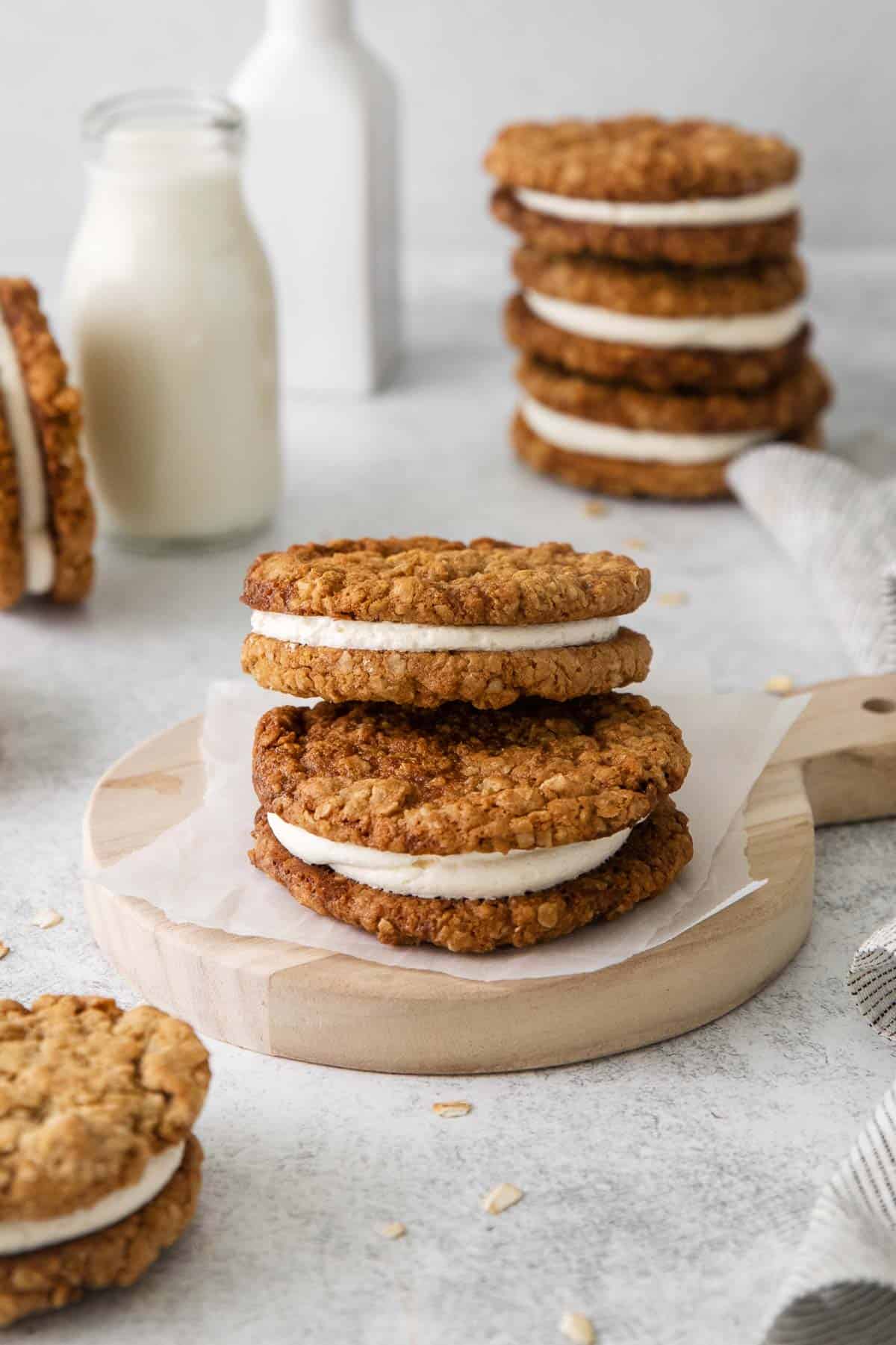 oatmeal cream pies on a platter, with milk and more cookies in the background
