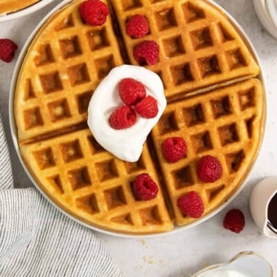 gluten-free waffles on a plate with whipped cream and berries