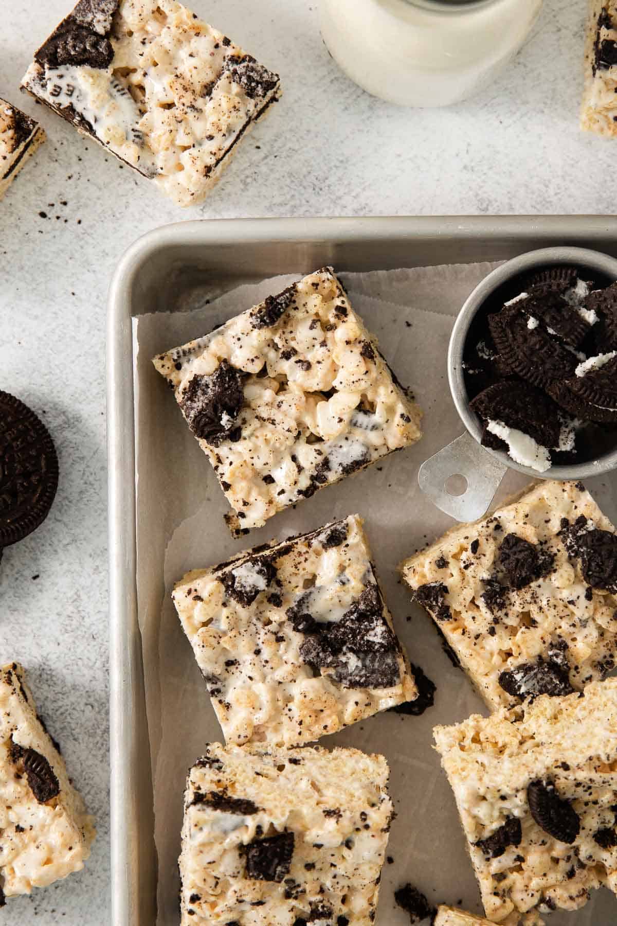 Gluten-free Oreo rice crispy treats cut into squares on a baking sheet with Oreo crumbles 
