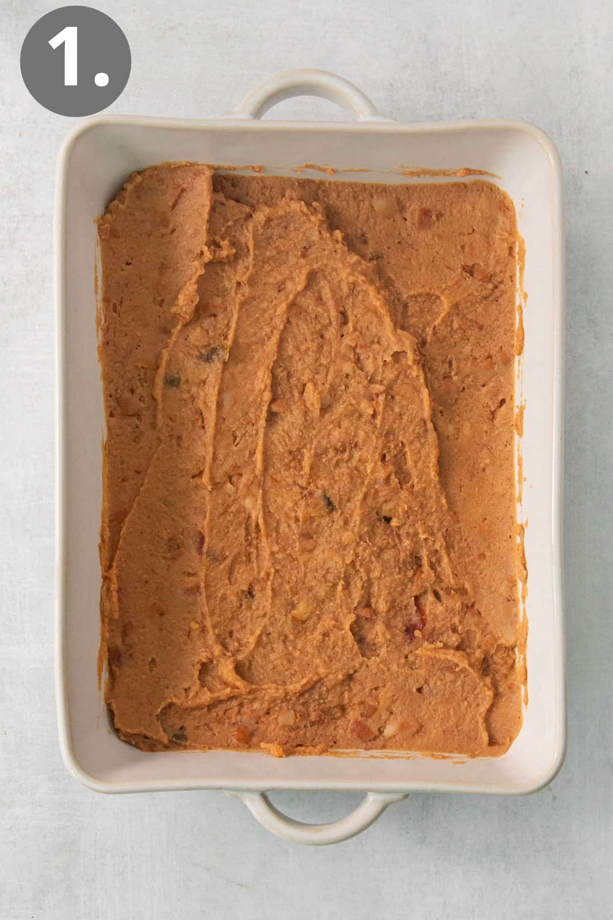 Refried beans layered in a baking dish
