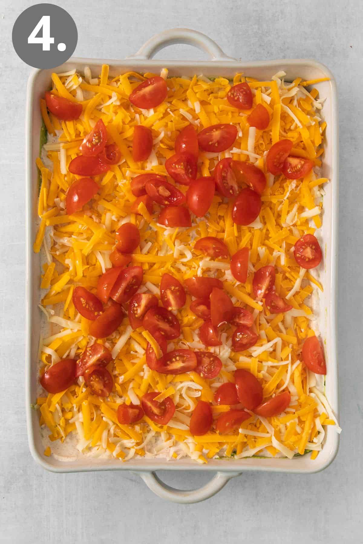 Tomatoes and cheese layered on top of the dip