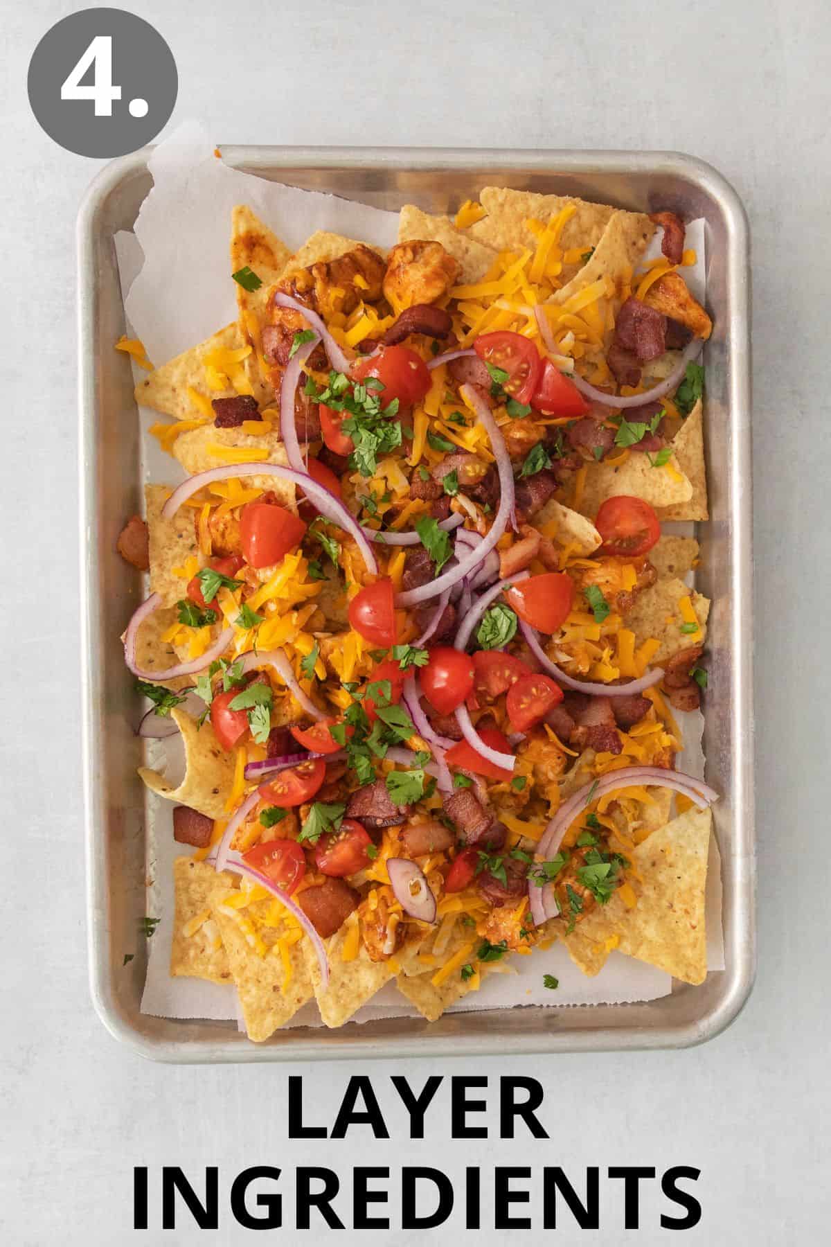 The first layer of nacho ingredients layered on a sheet pan