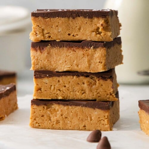 Peanut butter bars stacked on top of each other on a countertop