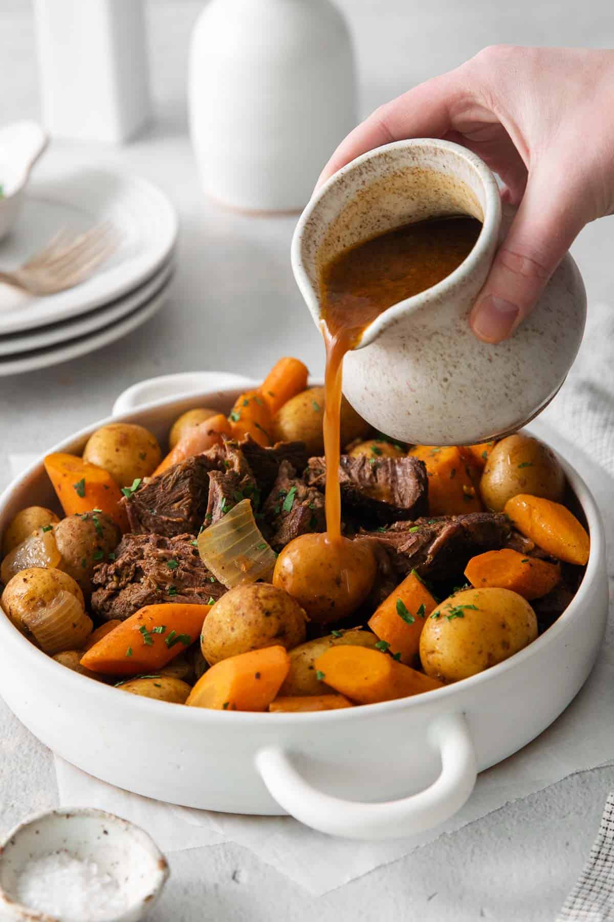 Sirloin roast with carrots and potatoes in a baking dish with gravy poured over top