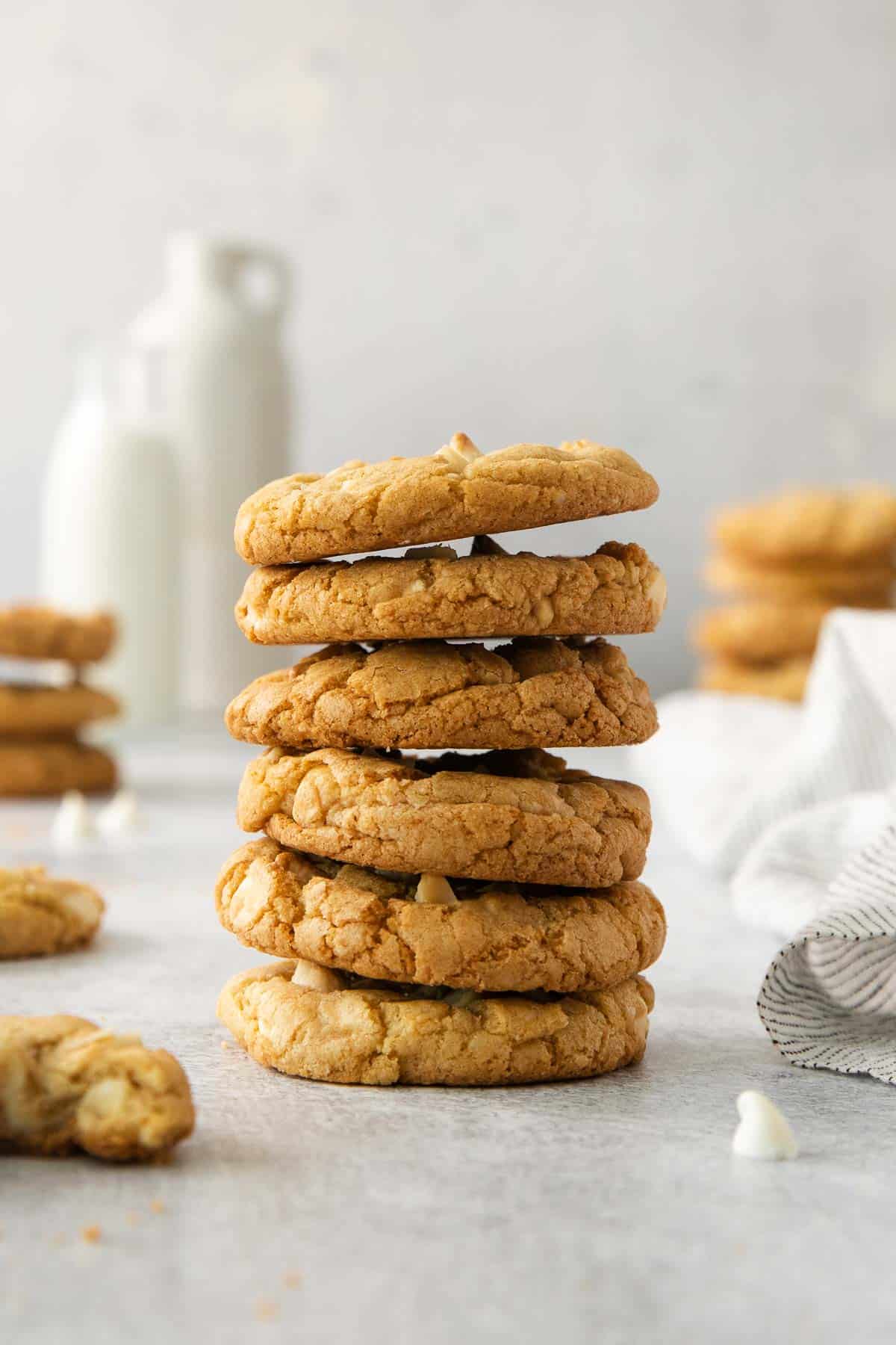 White chocolate macadamia nut cookies stacked on a countertop