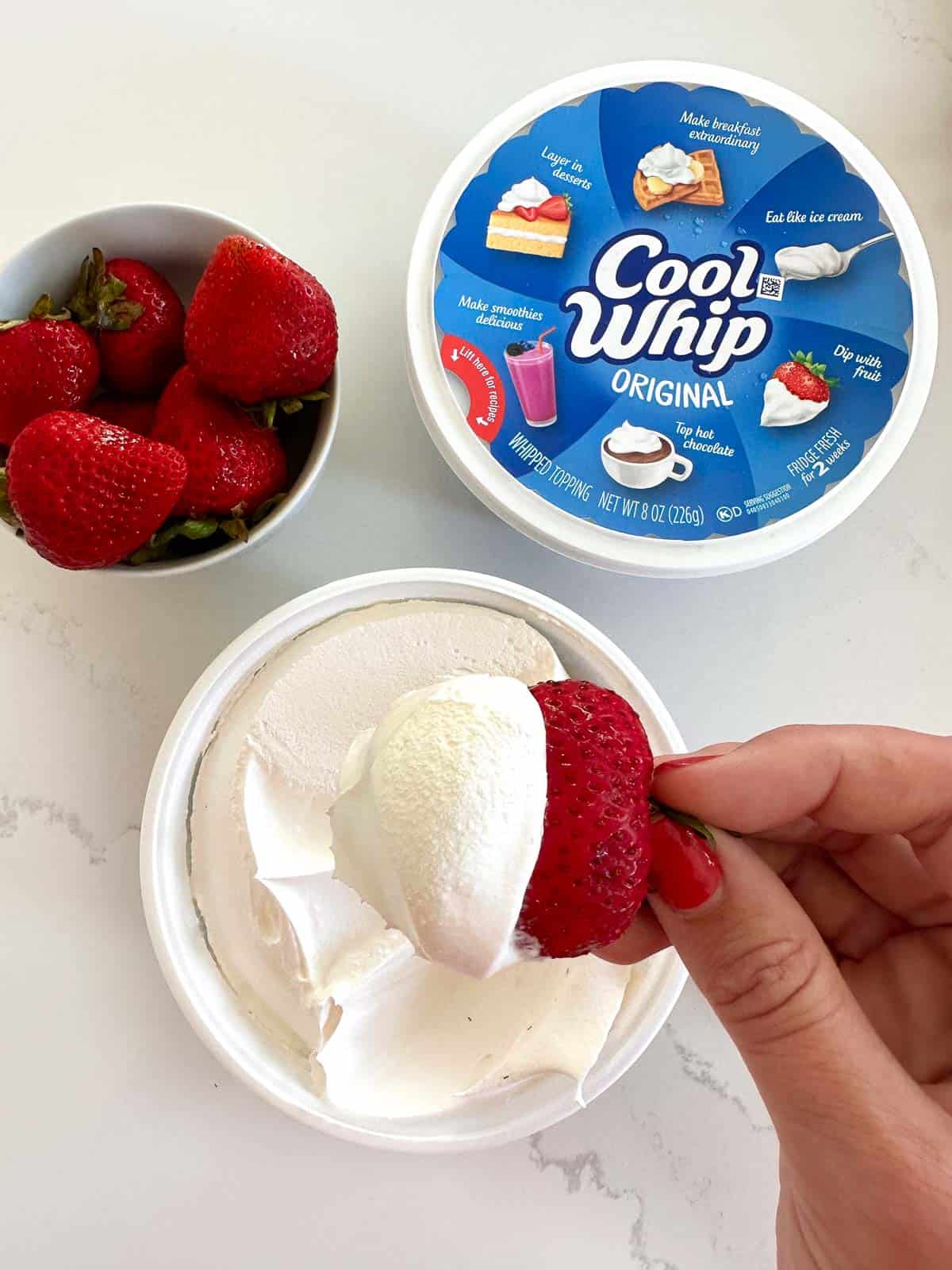 cool whip with strawberry being dipped