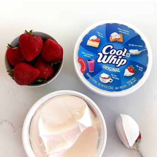 overhead shot of cool whip with strawberries with text overlay with text "is cool whip gluten-free"