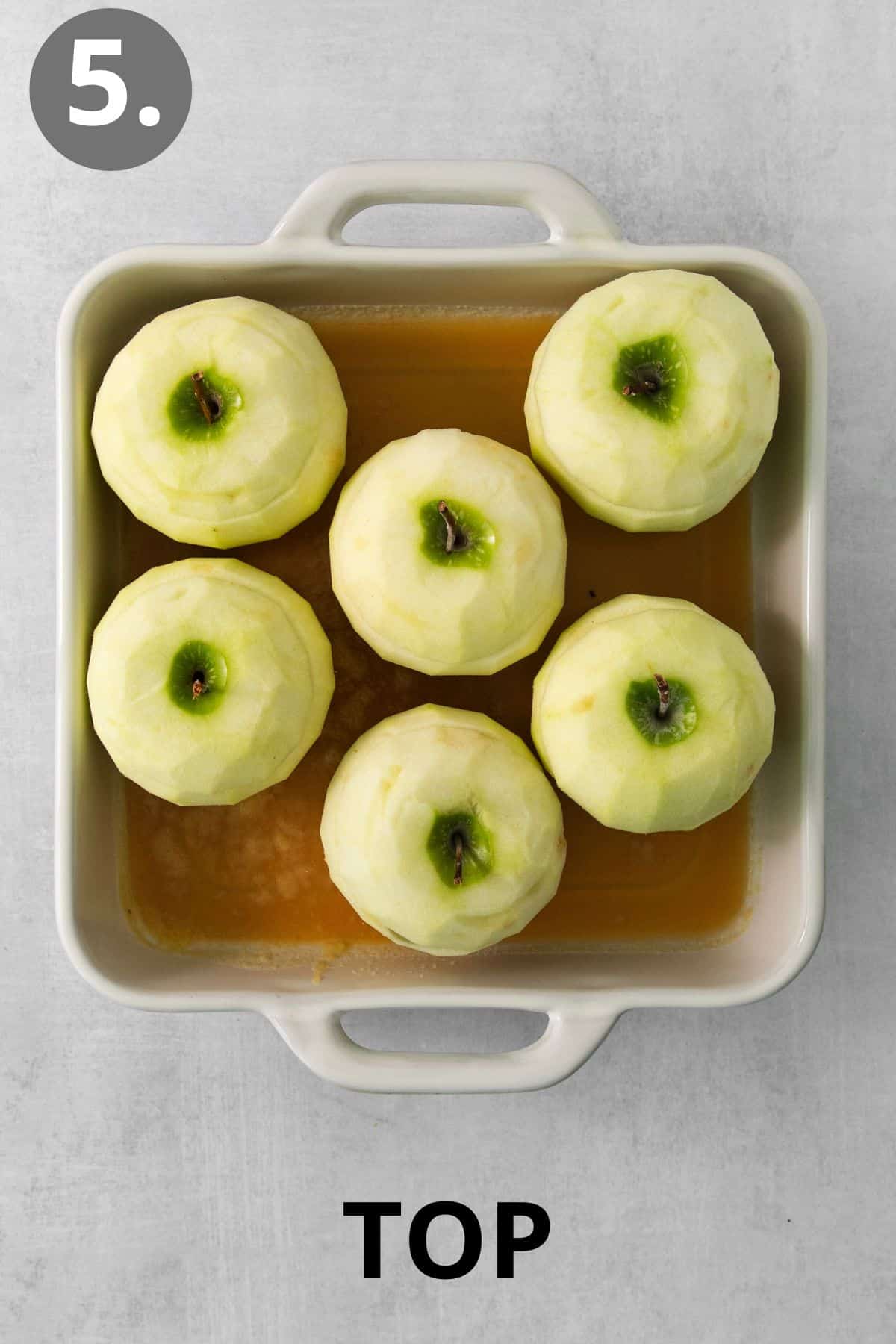 Baked apples with tops on them in a baking dish