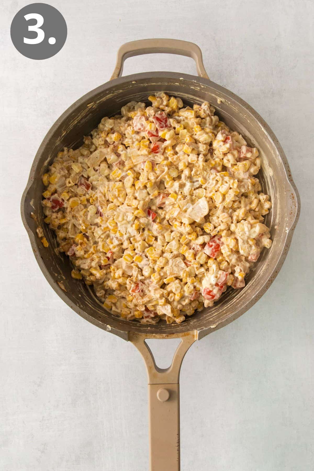 Cream cheese, milk, and seasonings added to the cream cheese corn in a skillet
