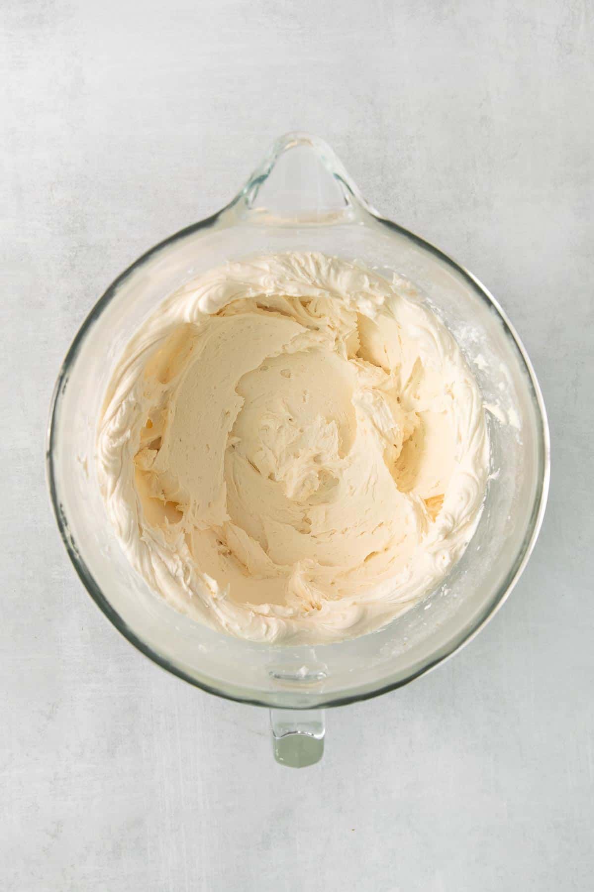 Cream cheese frosting in a glass mixing bowl