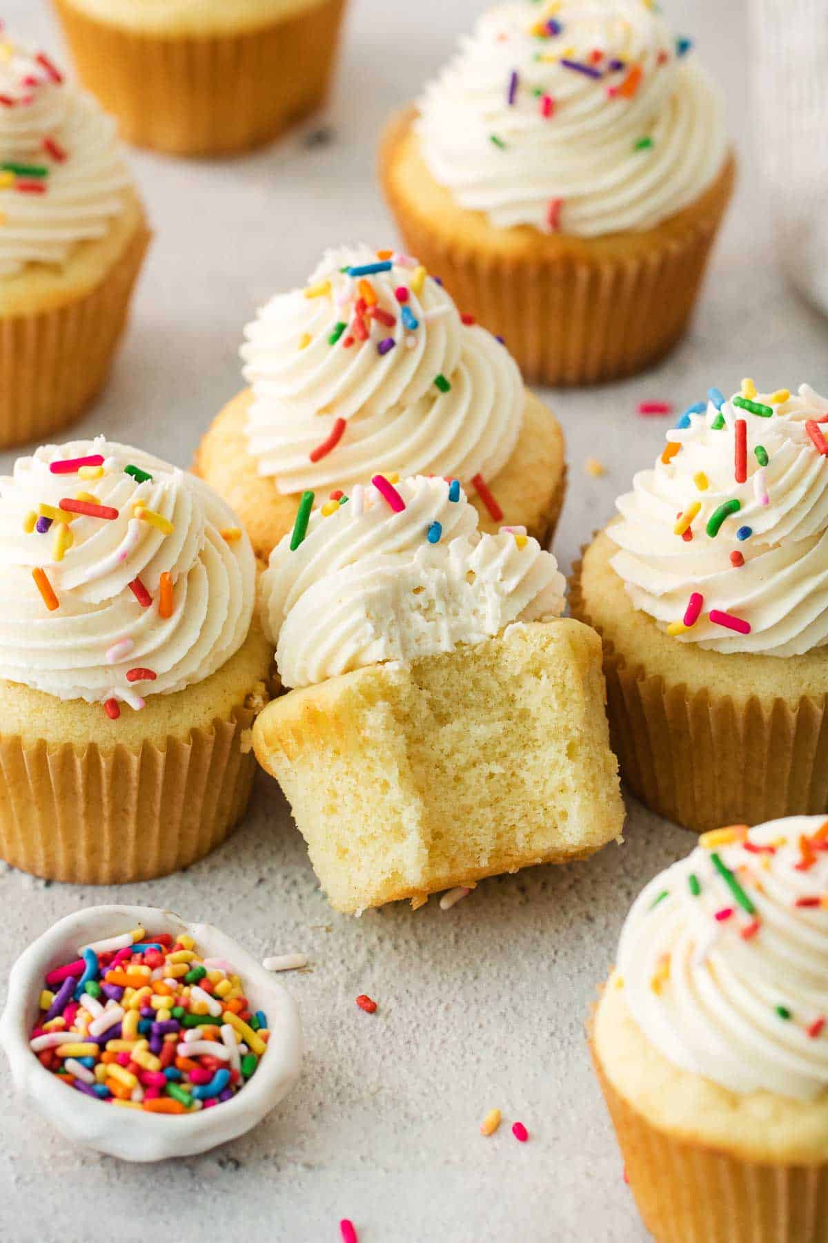 gluten-free vanilla cupcakes with sprinkles on a countertop