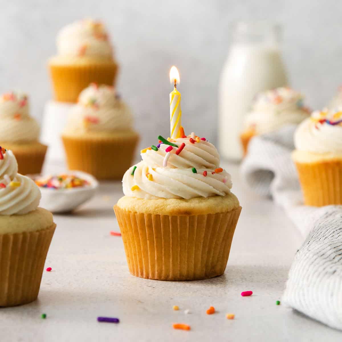 a gluten-free vanilla cupcake with a candle in it