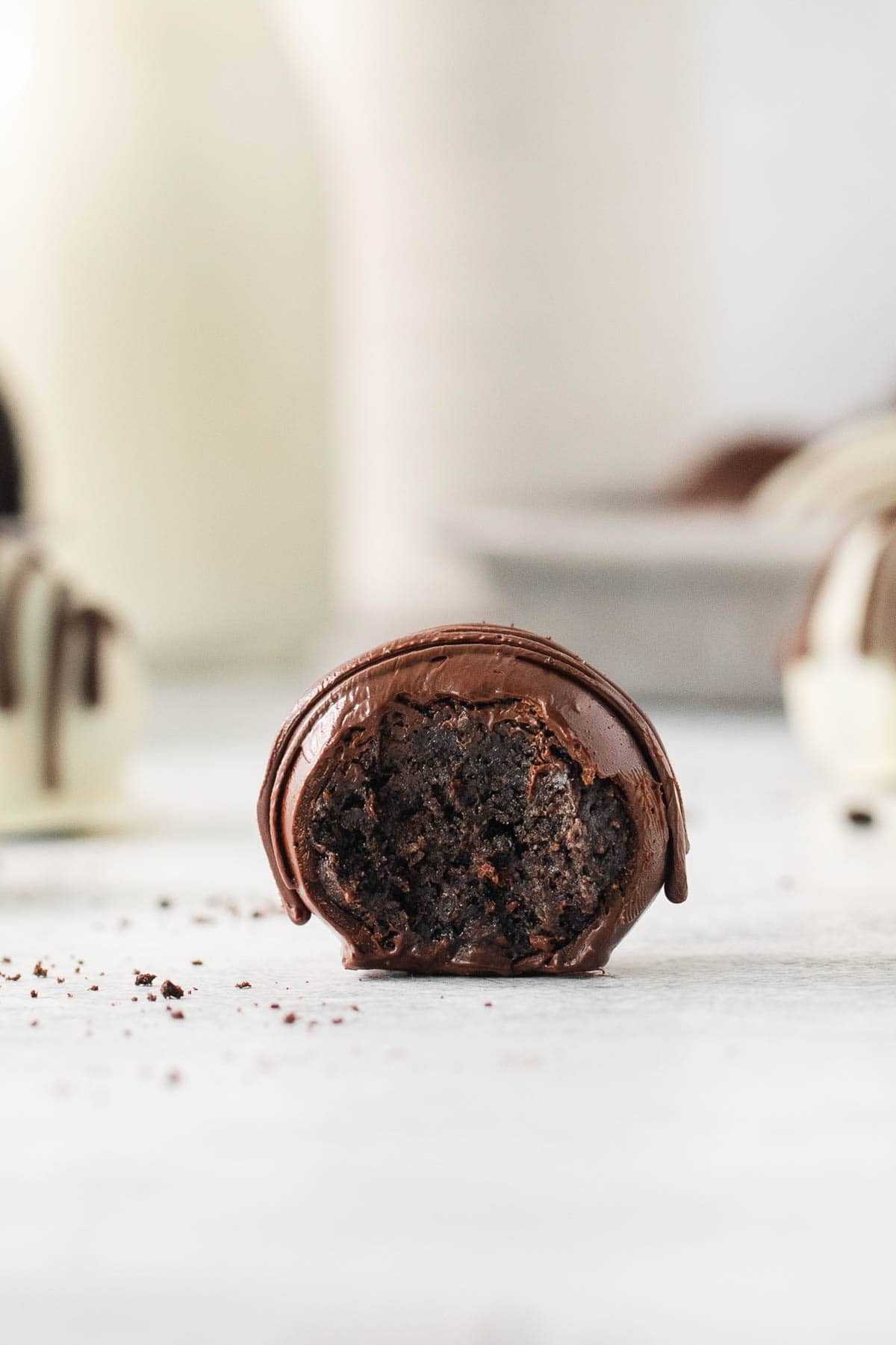 One gluten-free Oreo truffle on a countertop with a bit out of it